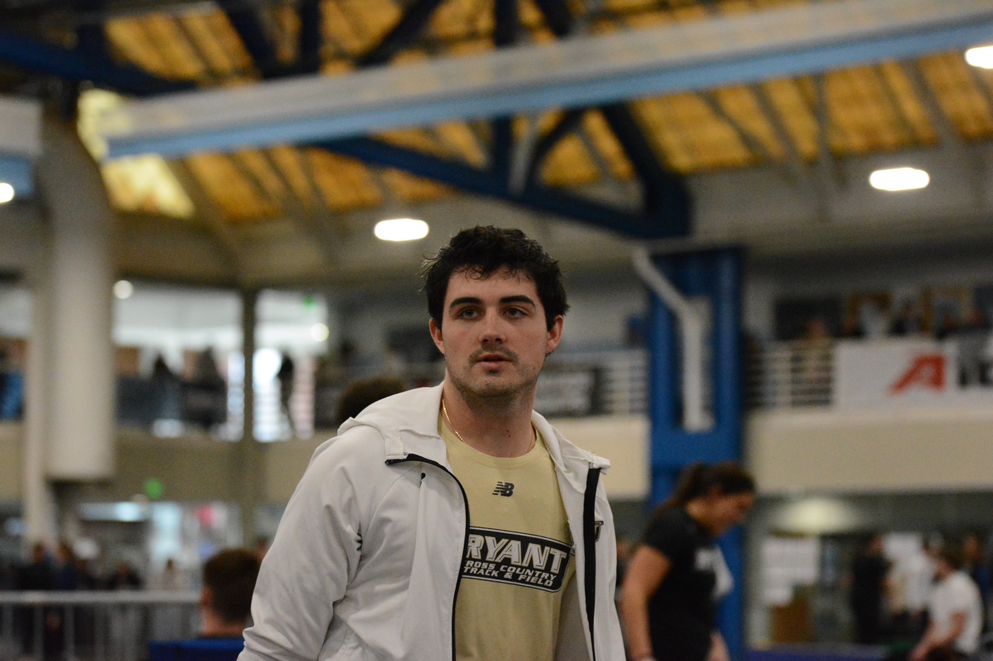 Jake Martino track and field wearing a gold shirt