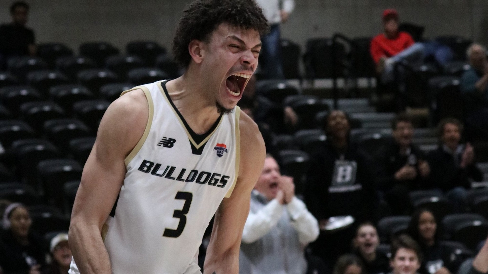 Aaron Davis III yells in excitement after dunking vs UMBC