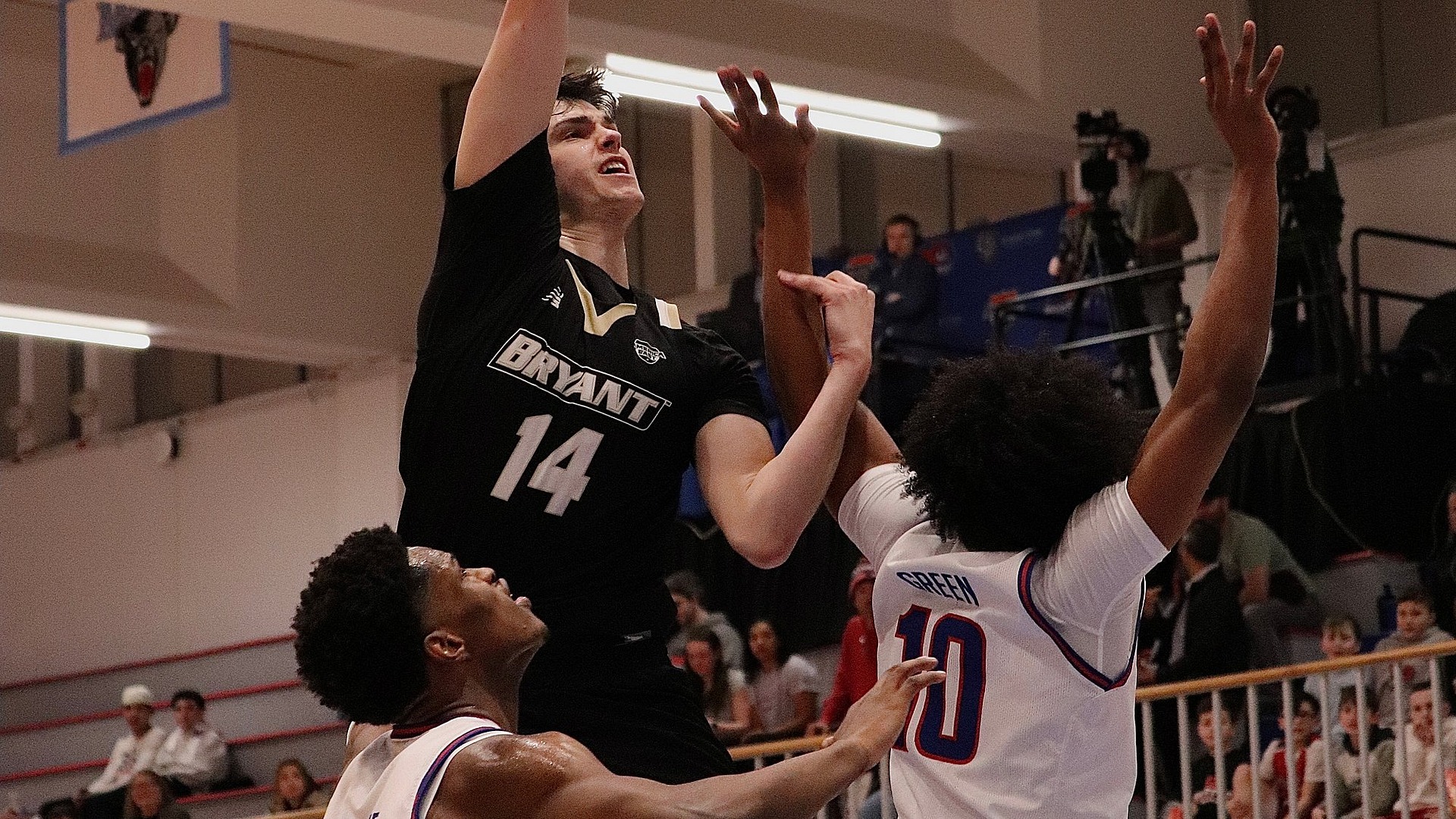 Keegan Harvey Goes up for a shot over two UML defenders