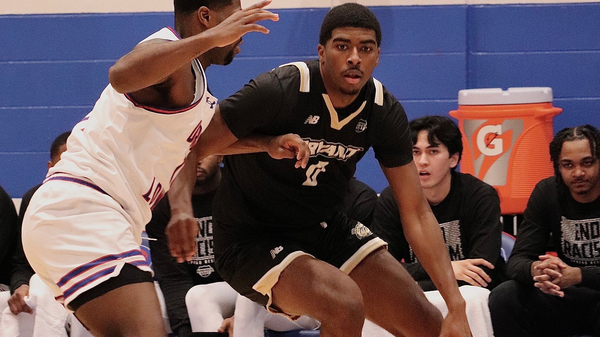 Ashley Sims II dribbles the ball against a defender at UML