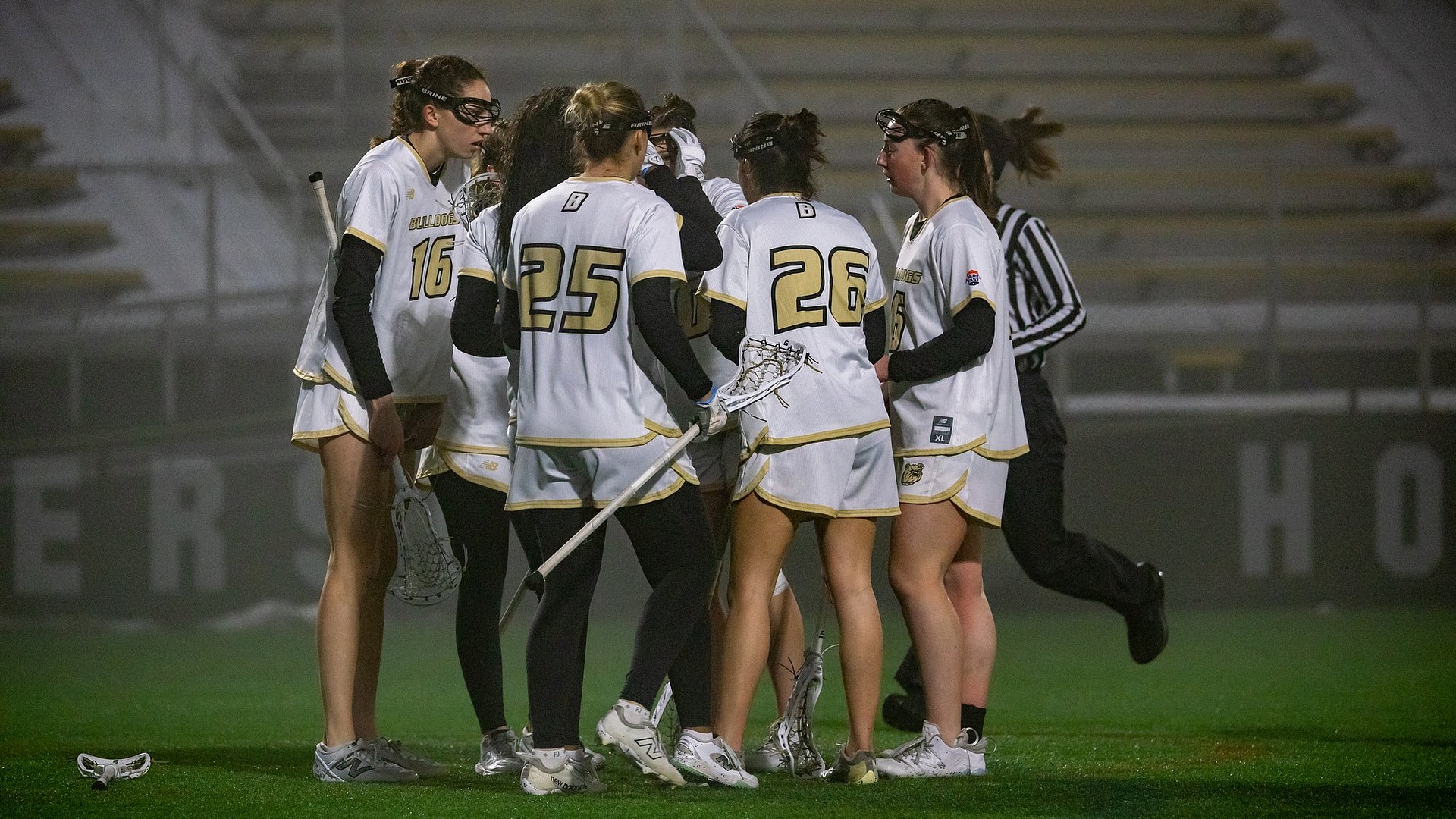 Women's Lacrosse Team huddles vs Harvard in the fog