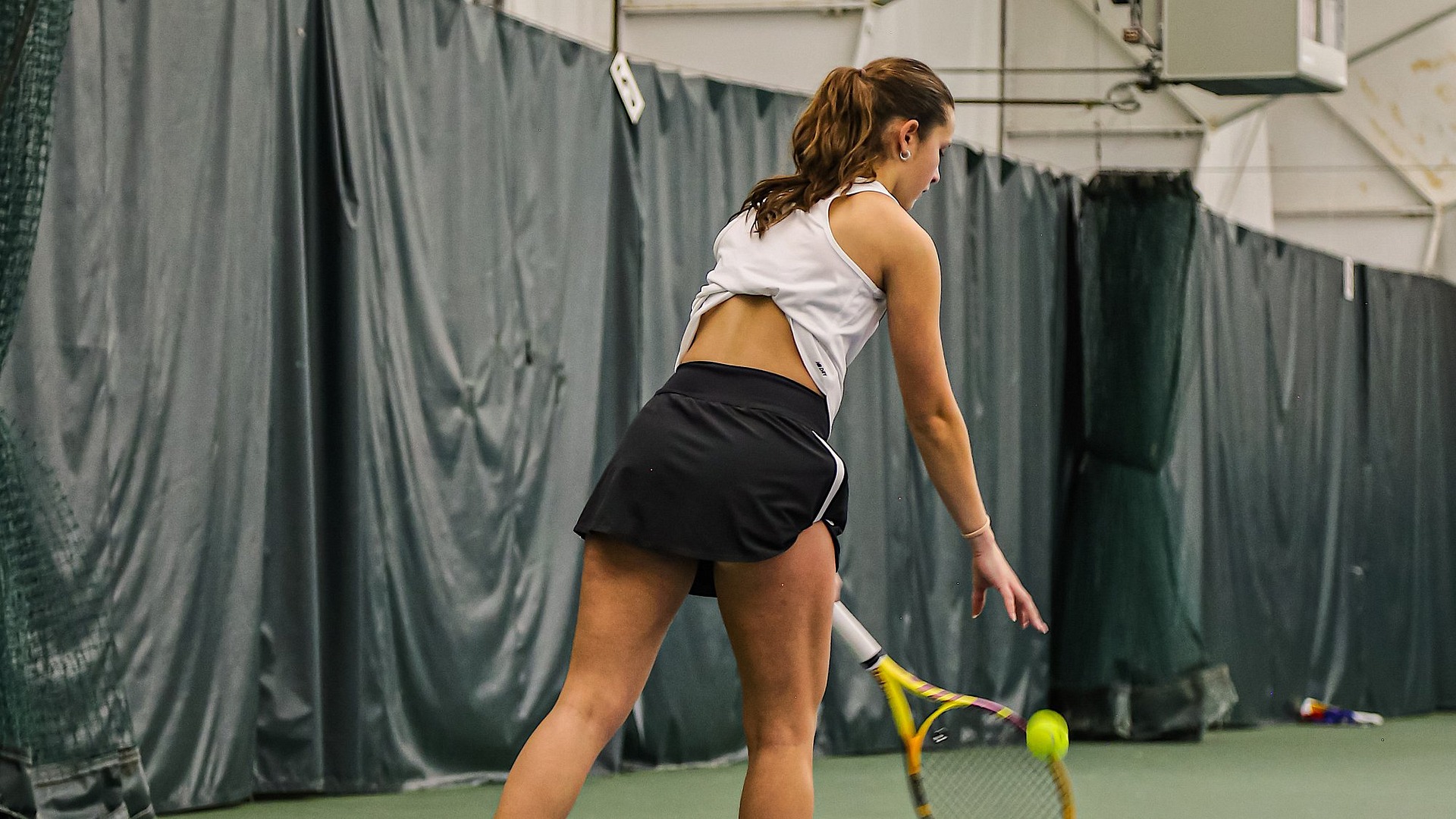 Mila Martinez bouncing ball before serving