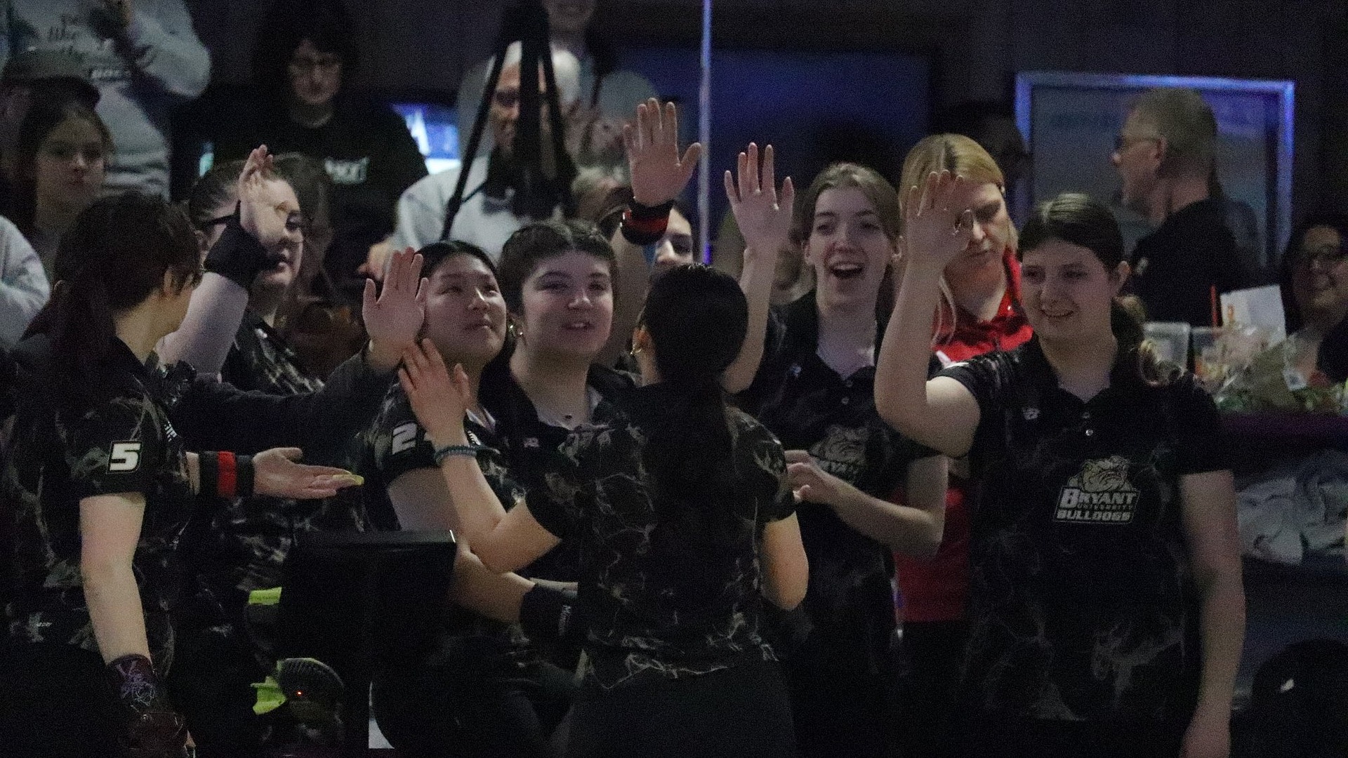 Bowling high fives in team huddle