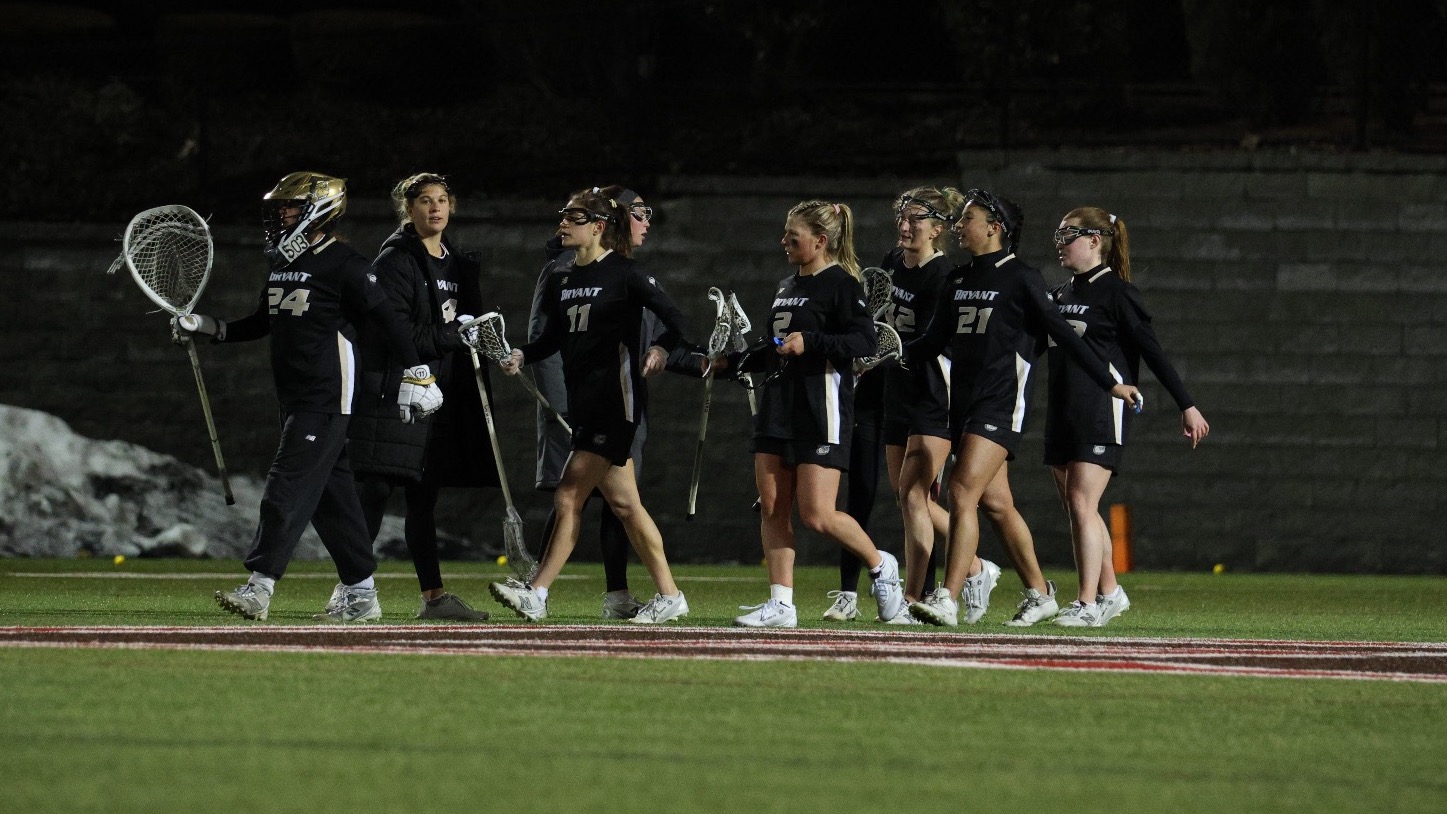 Wlax team walks up the field at brown