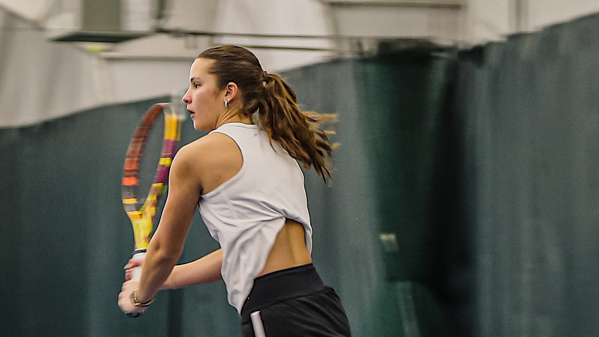 Mila Martinez running to hit a backhand shot