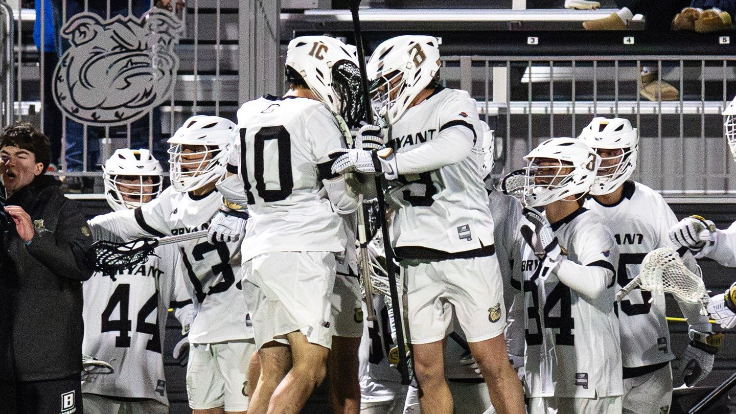 two men's lacrosse student-athletes celebrating their first conference win of the season