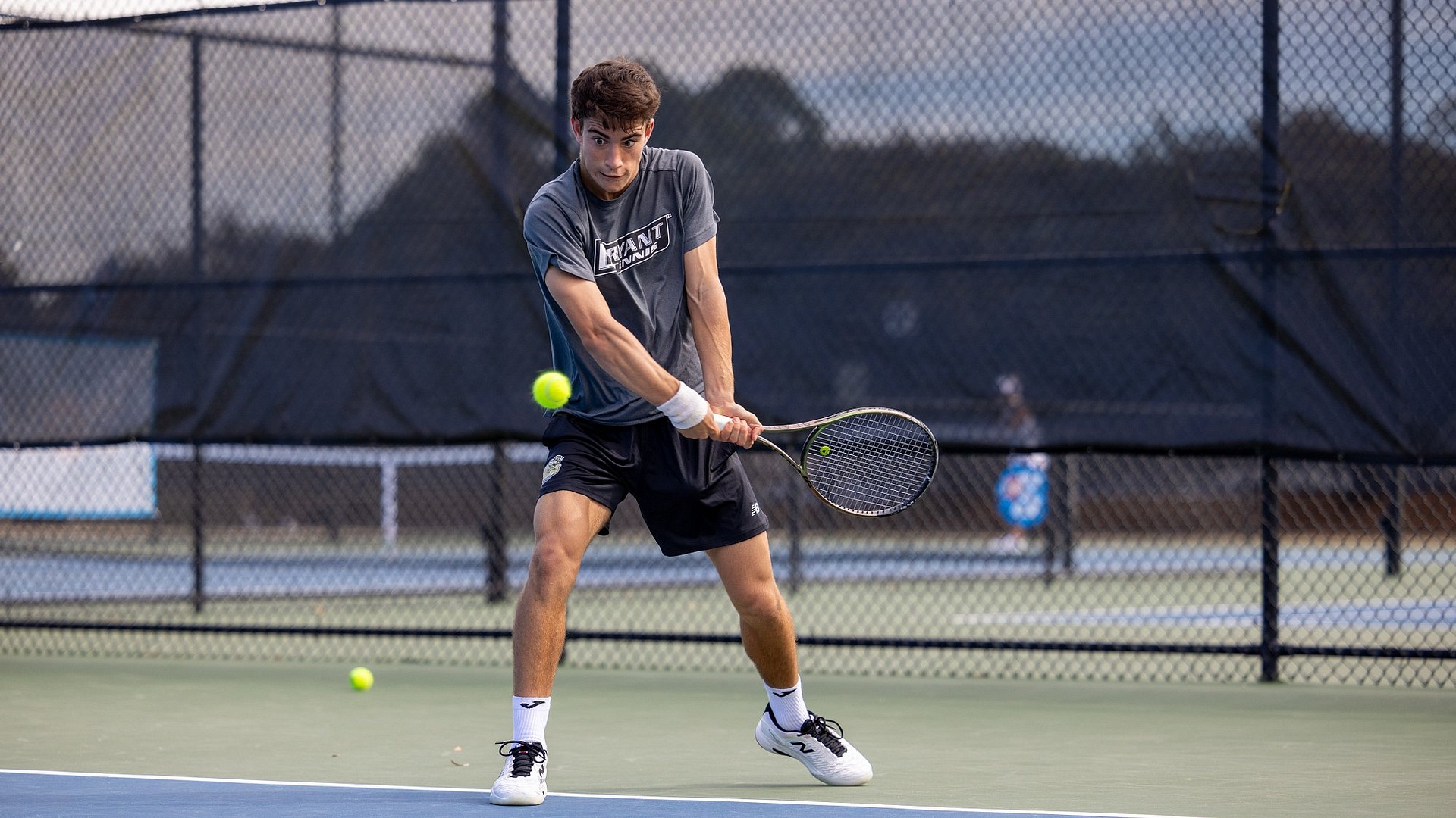 Miguel Machado striking a backhand shot on the strings of his racket