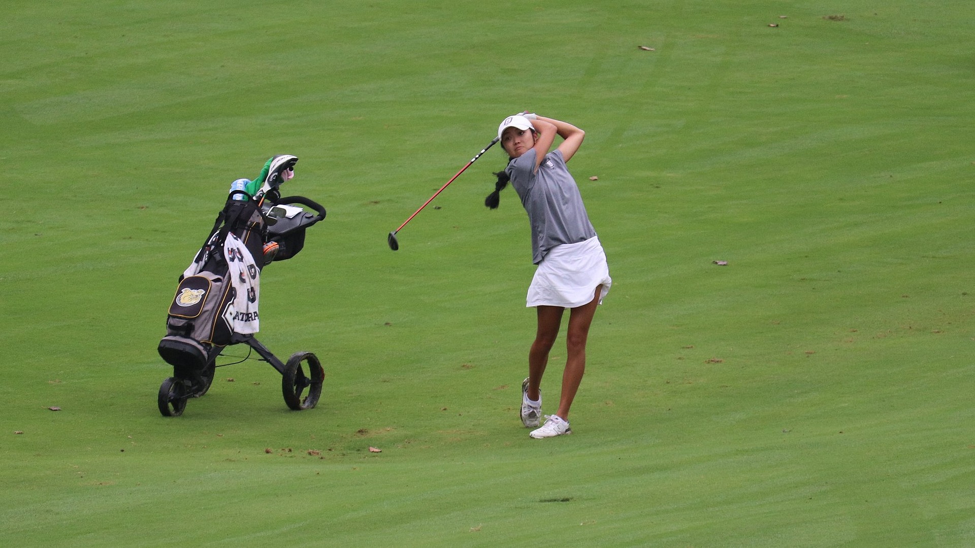 Jenelle Valera following through a drive and admiring it 