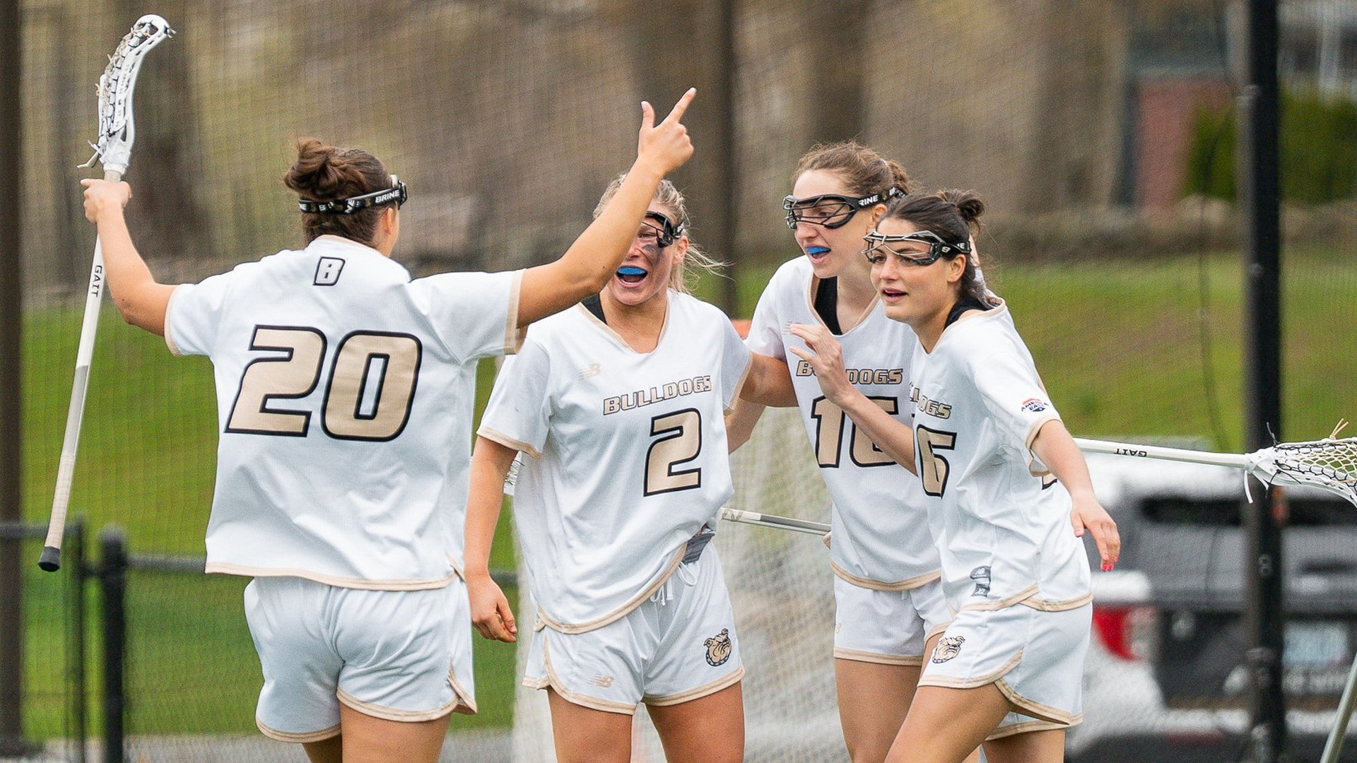 Women's Lax team huddle after goal vs UMBC
