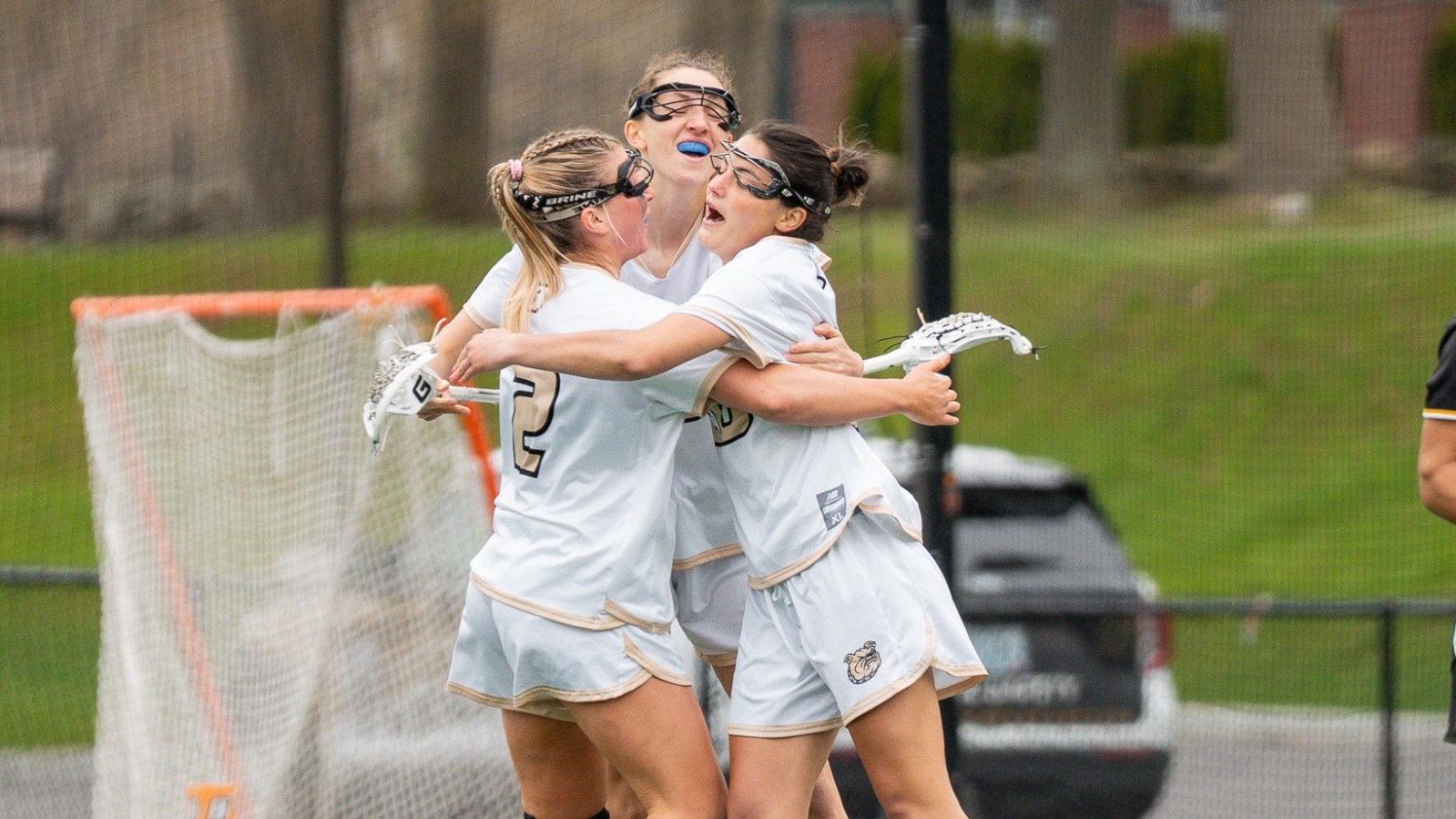 Three women’s lacrosse players Celebrate vs UMBC