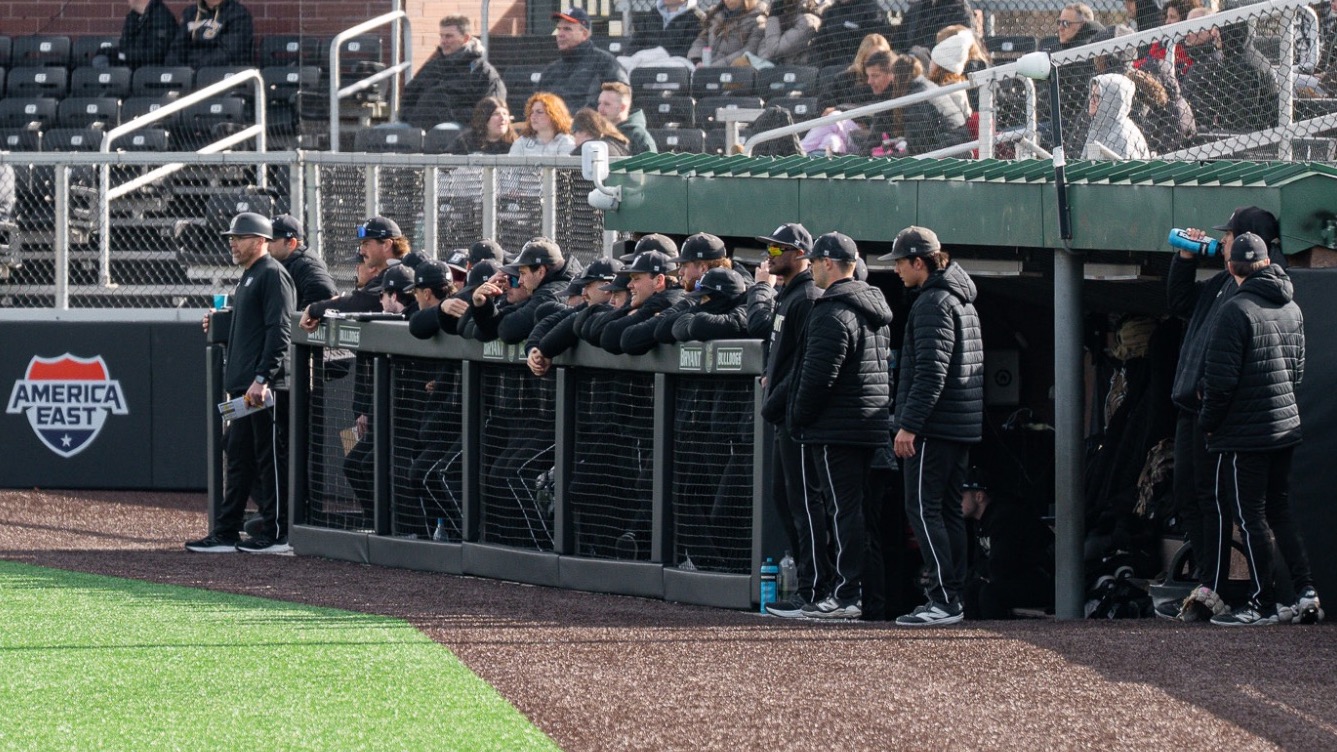 Picture of players standing in the Bryant baseball dugout