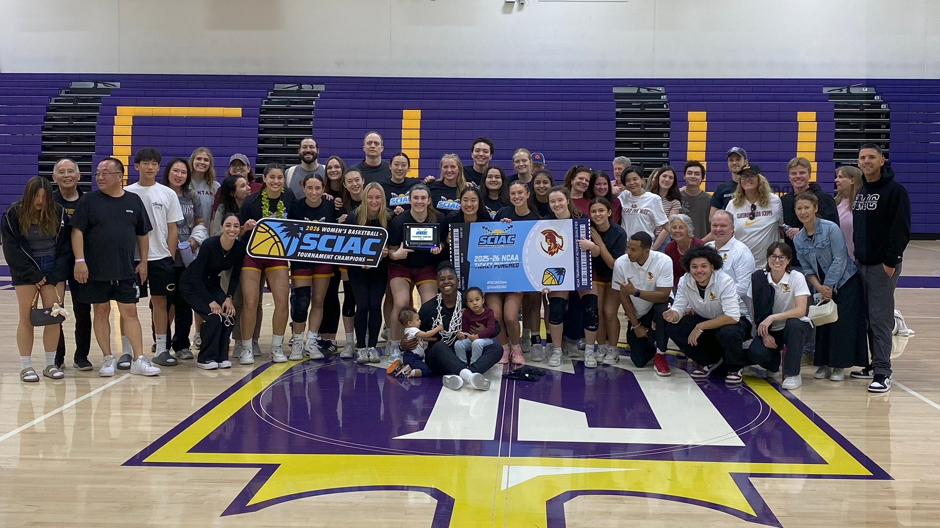CMS Women's Basketball team with their families and the SCIAC banner