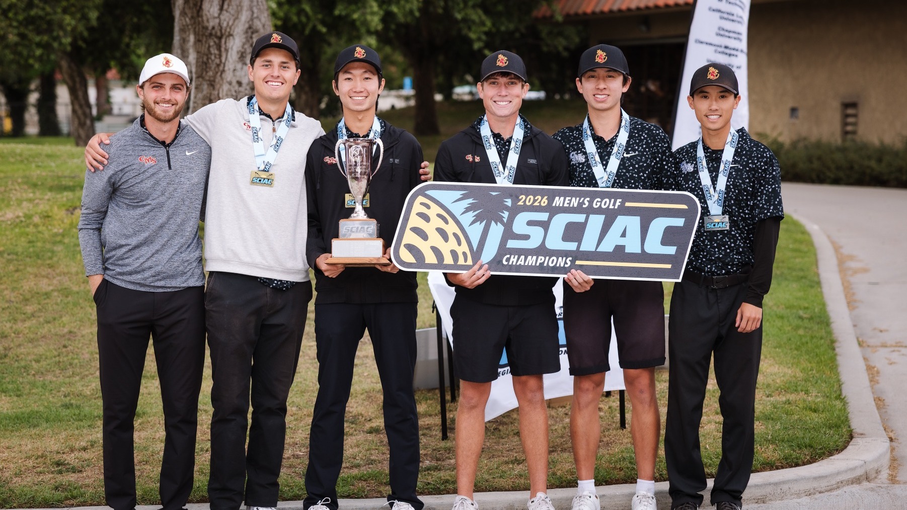 CMS Men's Golf celebrates with the SCIAC Championship banner