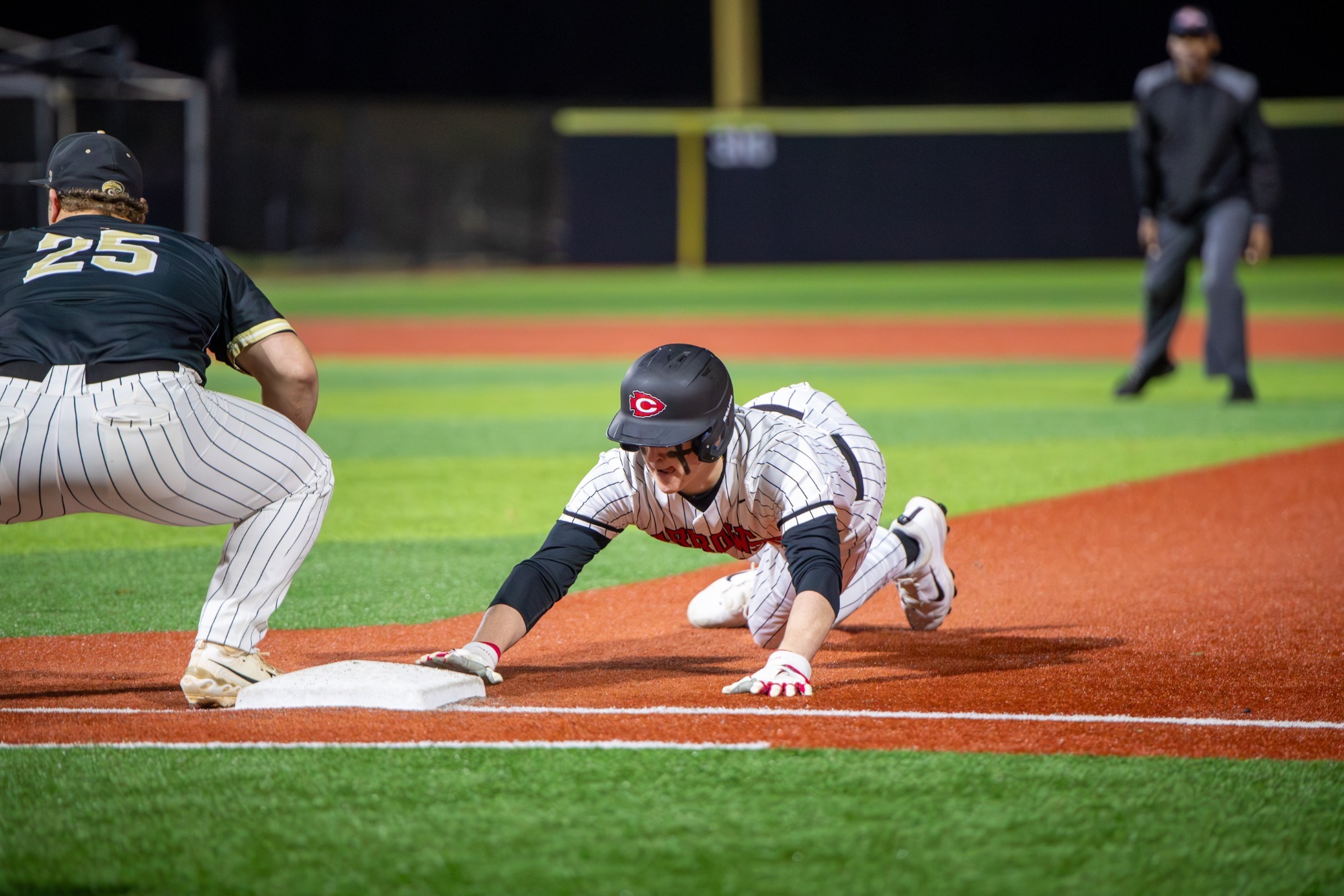 A Clinton Arrow slides back into first base.