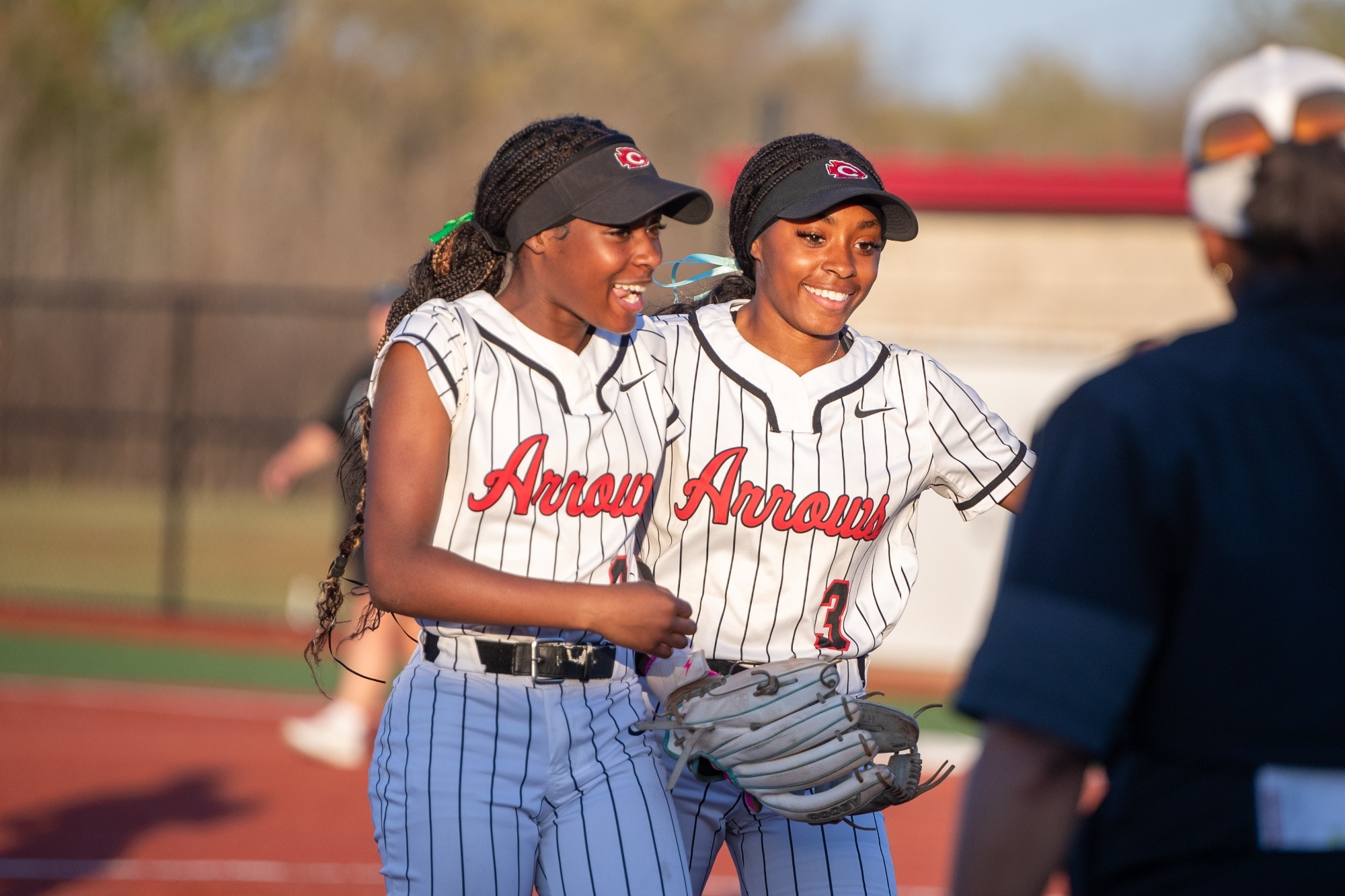 Two Lady Arrows celebrate an inning-ending out.