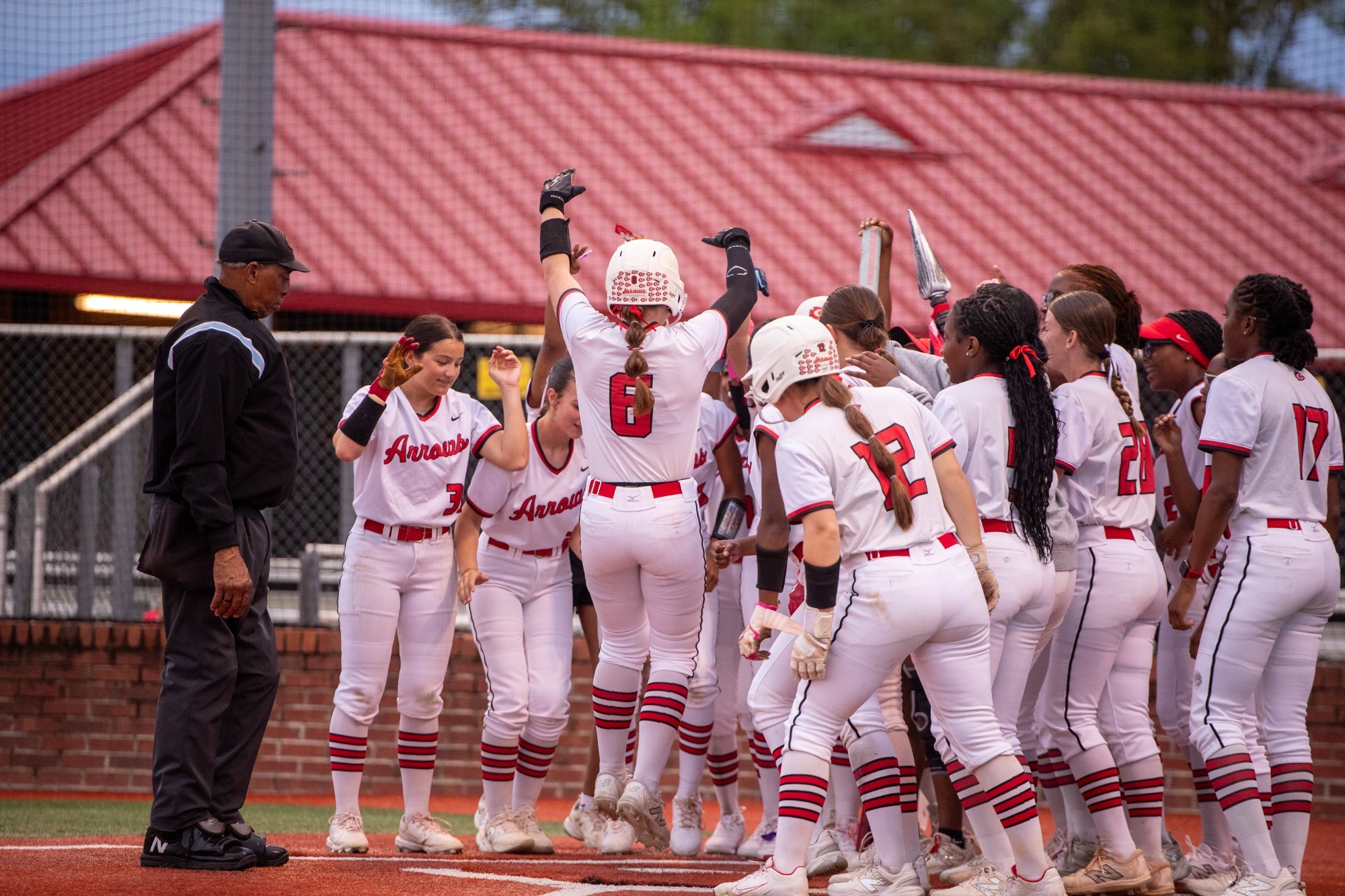 Presleigh Burrow and the Lady Arrows celebrate Burrow's solo shot in the second inning of a game against Murrah.