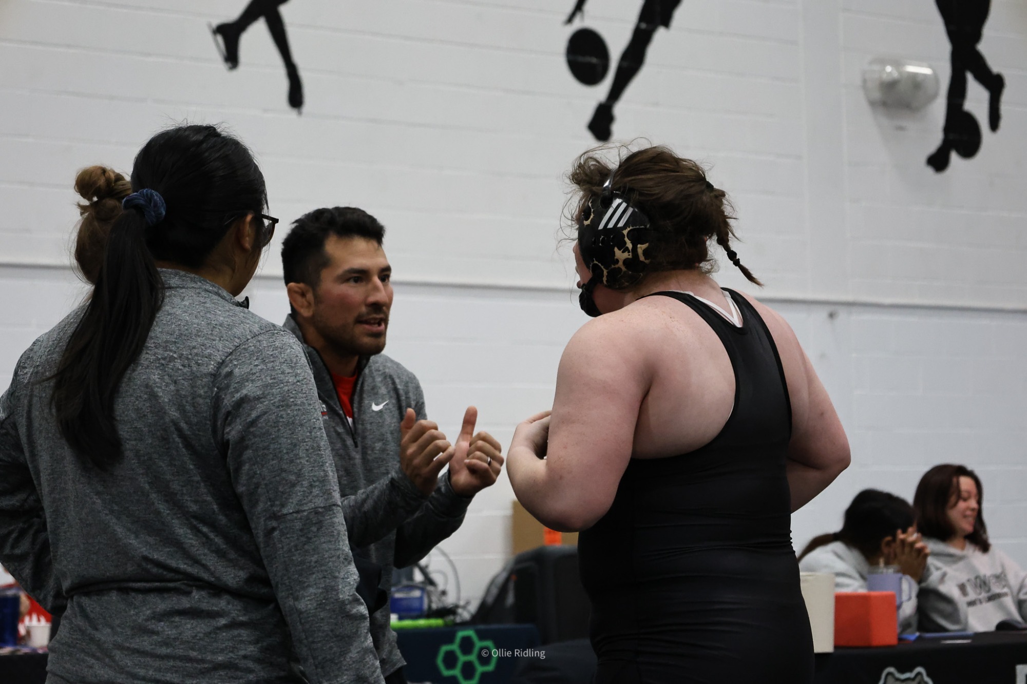 Elizabeth Stricklin talks with coaches