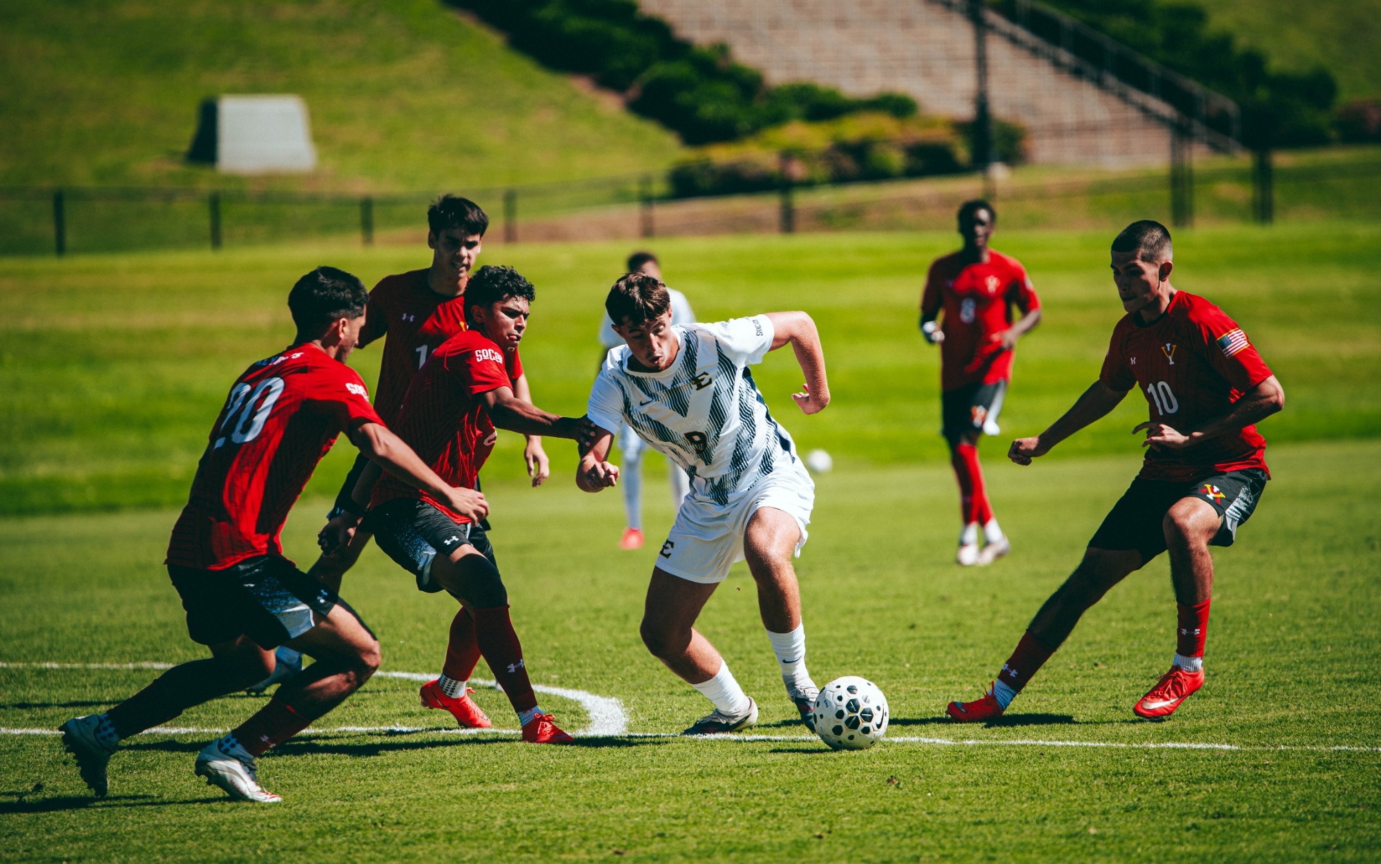 Gavin Dick eludes a group of red-clad VMI defenders attempting to surround him and take the ball away.