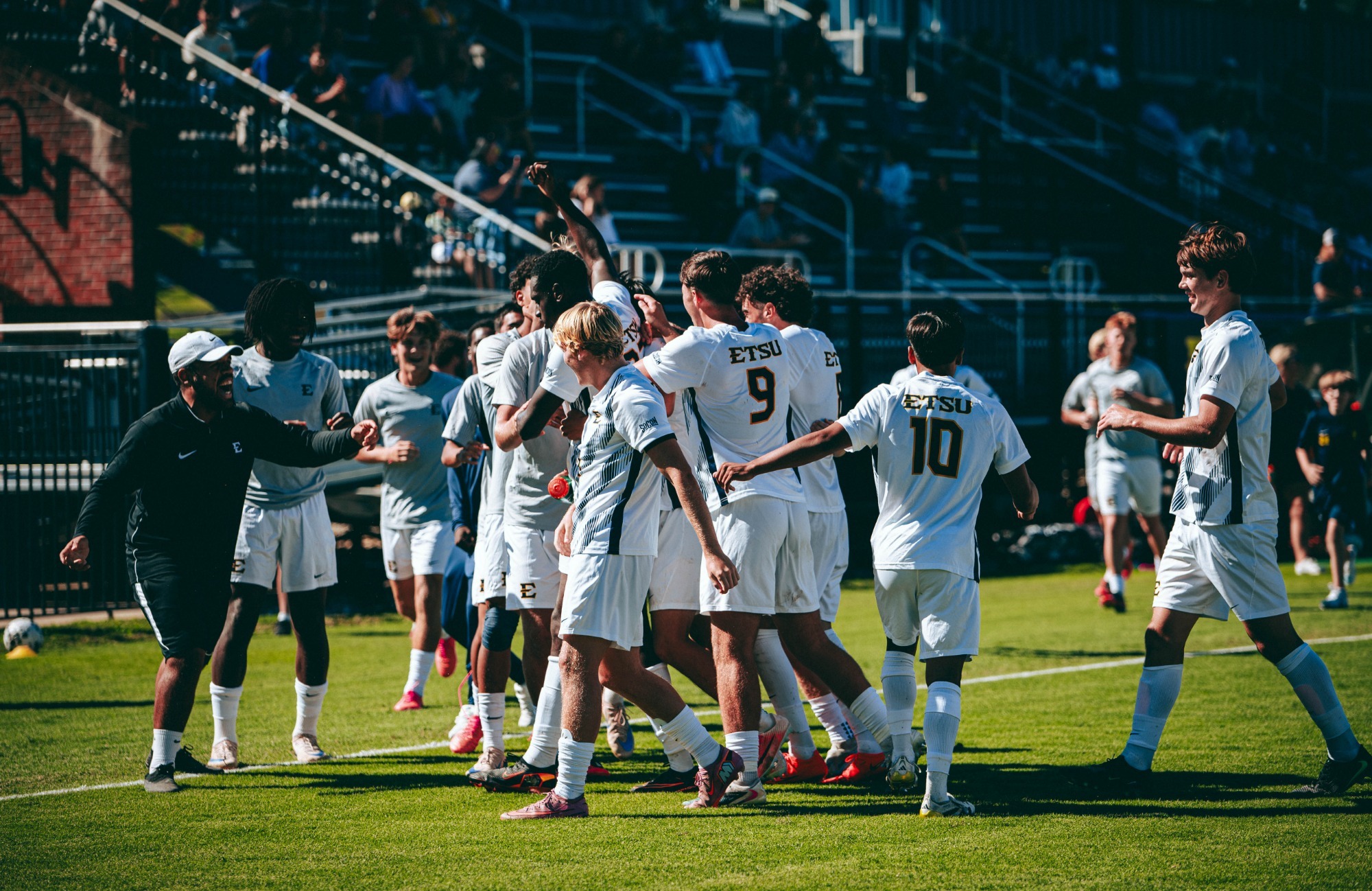 George Chunuwe is surrounded by his teammates as he celebrates a goal during a soccer match against VMI.