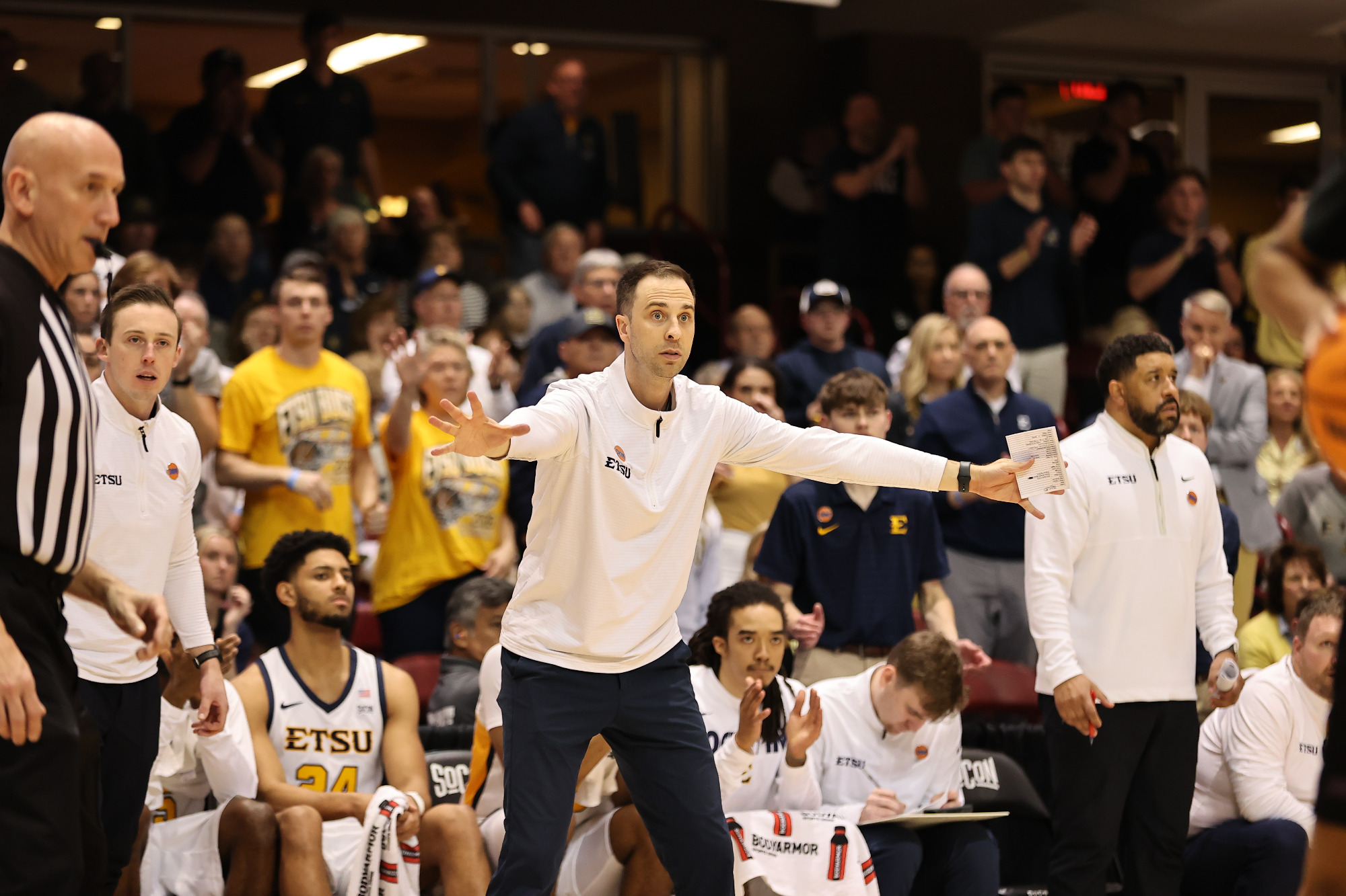 Brooks Savage extends his arms away from his body as he coaches his team on defense during a basketball game against Western Carolina.