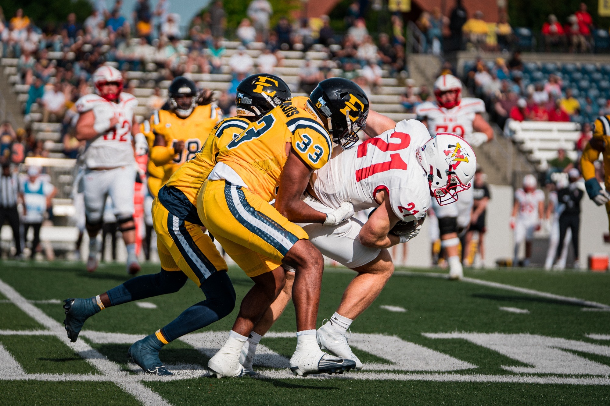 Mike Jenkins and Dre Delinois combine for a tackle in a game against VMI in 2025