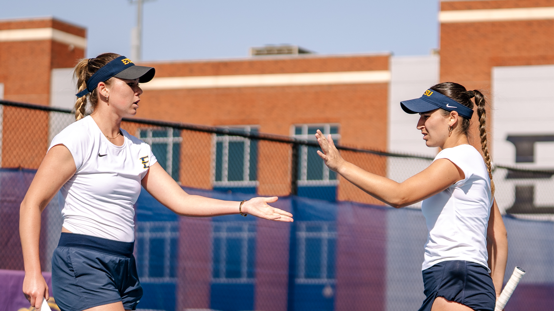 Ksenija Rage and Julia Millan go for a high five in a match against Appalachian State