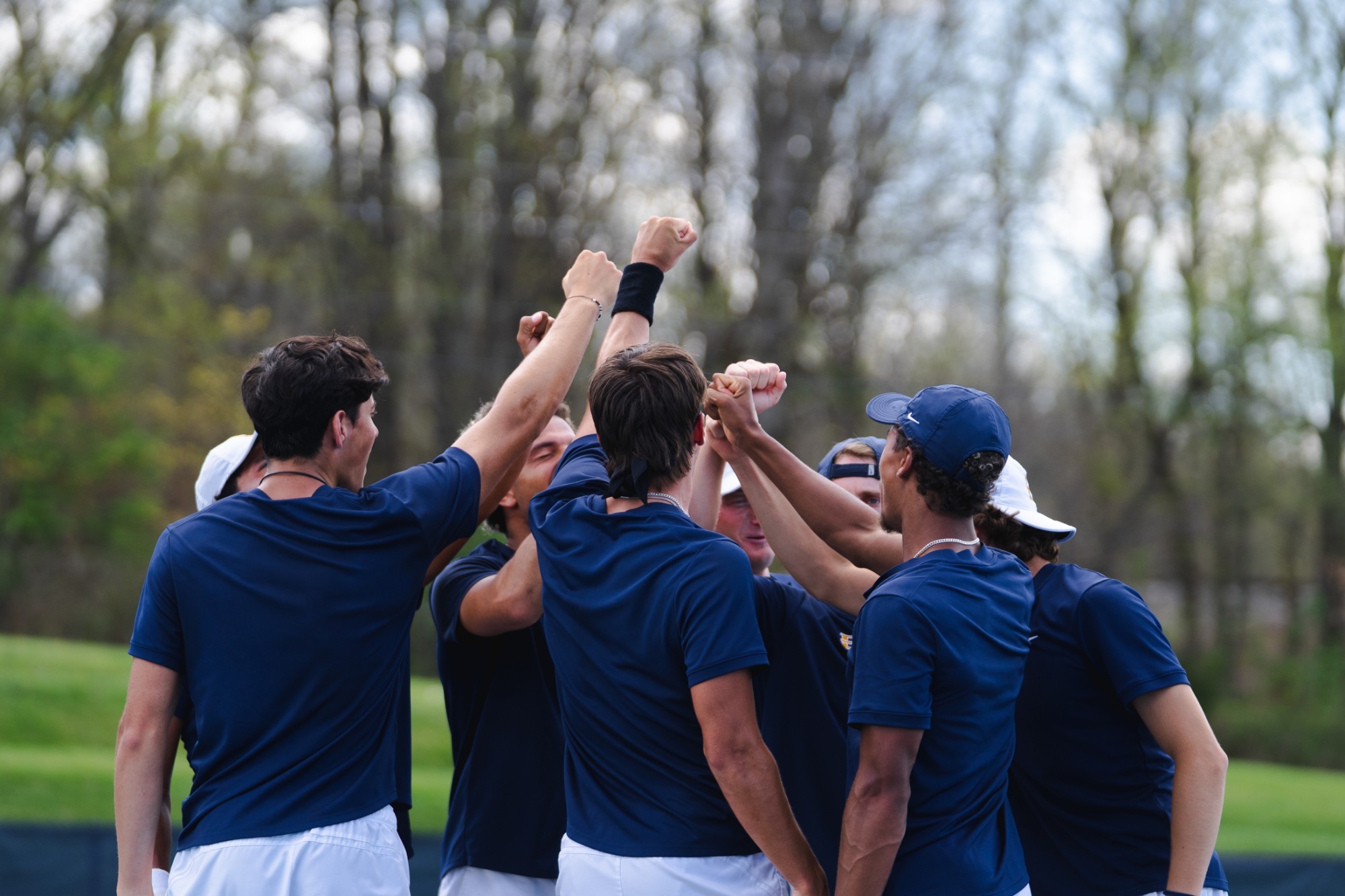 ETSU men's tennis team in a huddle during its match against Chattanooga