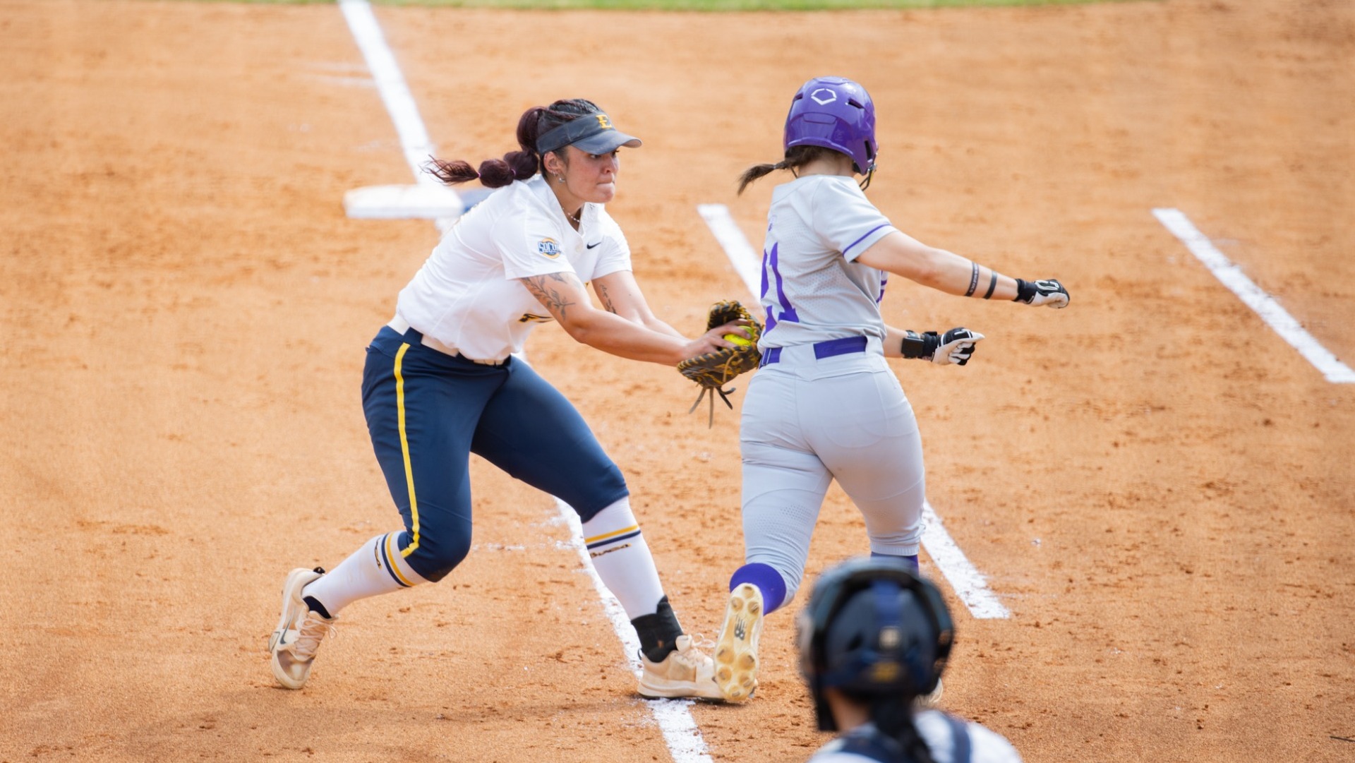 Softball's Riley Martens playing first base and tagging a Western Carolina runner out on the first base line.