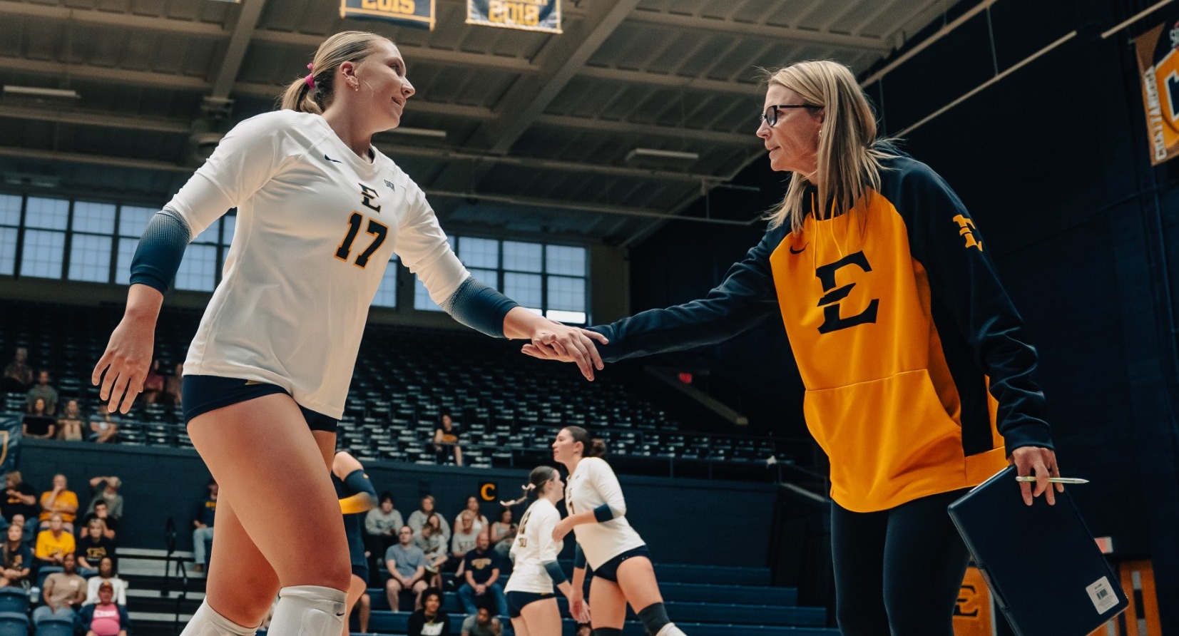 Volleyball's Lindsey Devine and Bailey Gohlke high-fiving as Gohlke subs off the court during a scrimmage against Gardner-Webb in the 2025 preseason