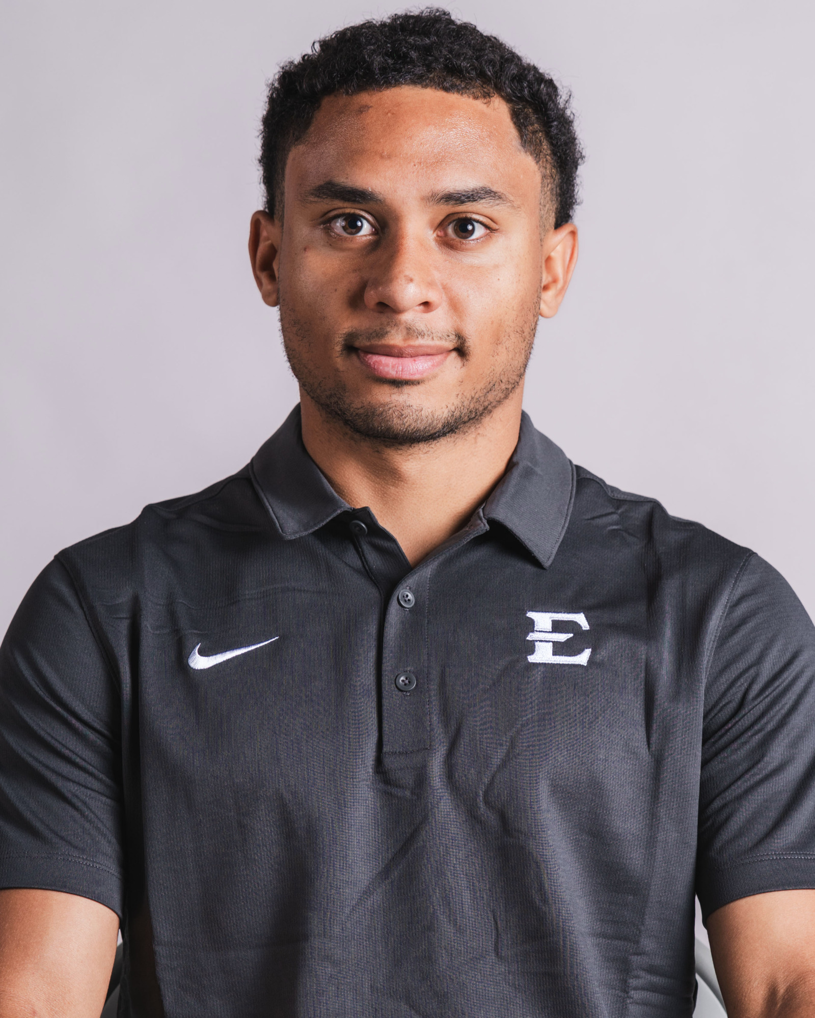 A headshot of JP Vital in his gray coach's polo.