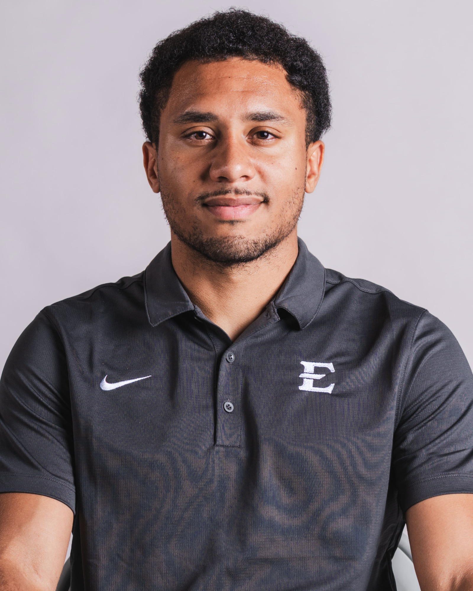 A headshot of Devin Vital in his gray coach's polo.
