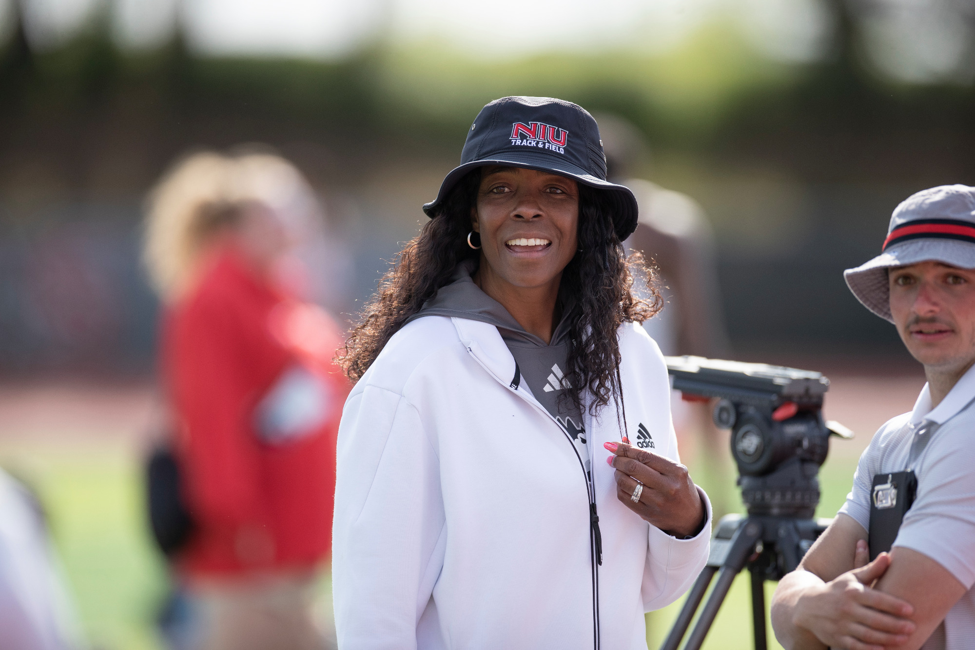 Connie Teaberry in a white jacket and black bucket hat during her time coaching for Northern Illinois.