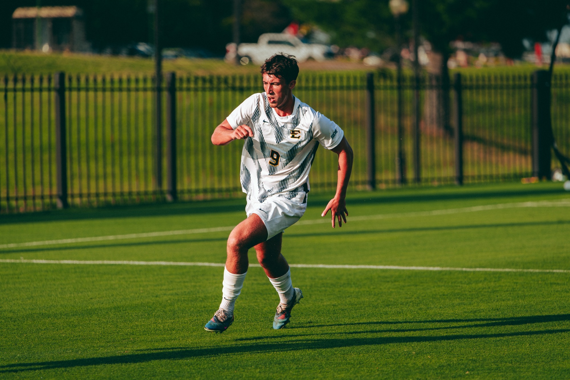 Gavin Dick chases an unseen soccer ball with the sun in his eyes during a match against USC Upstate.