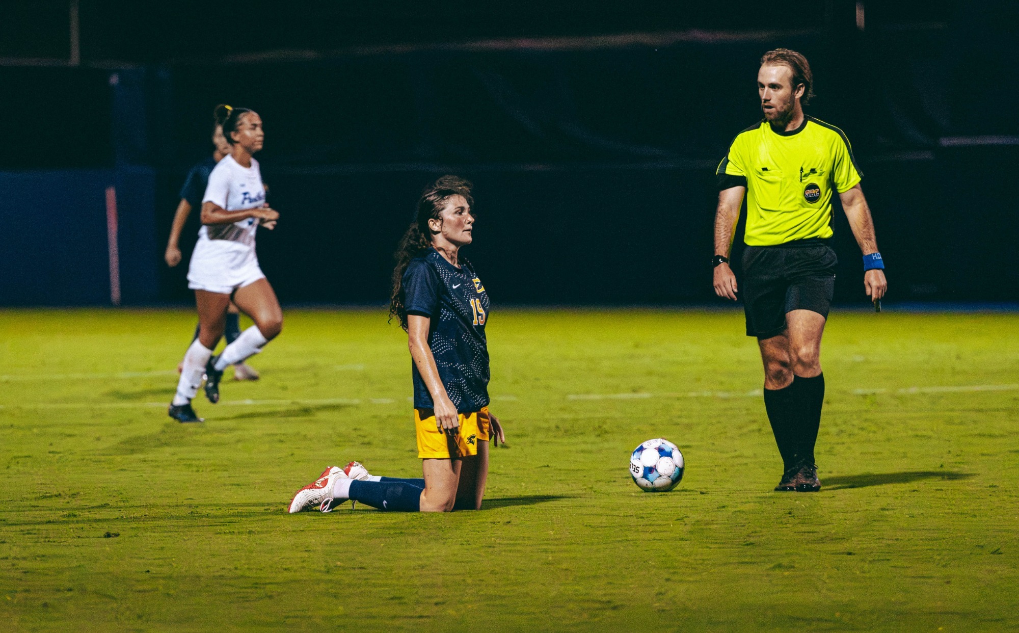 Reagan Fitzgerald sits up on her knees in front of a soccer ball during a stoppage in play in a match at Georgia State.