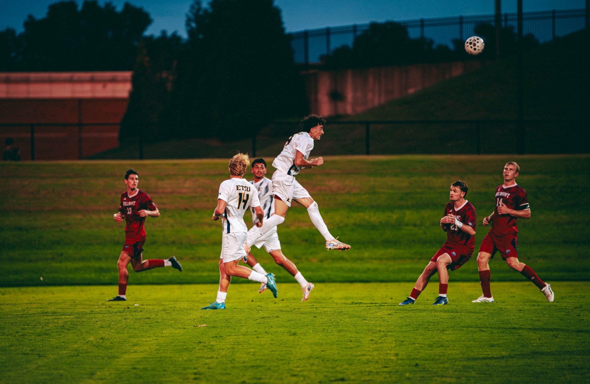 Matias Delellis leaps into the air for a header to send the ball back toward the goal out of frame during a soccer match against Belmont.