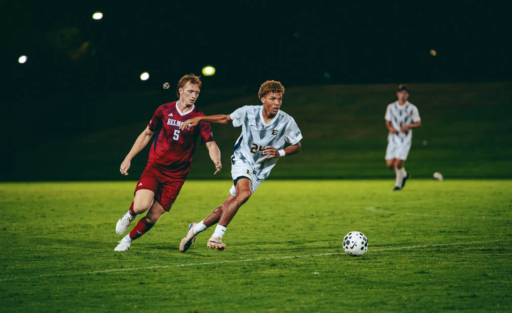 Jacob Hines dribbles away from a Belmont defender during a soccer game.