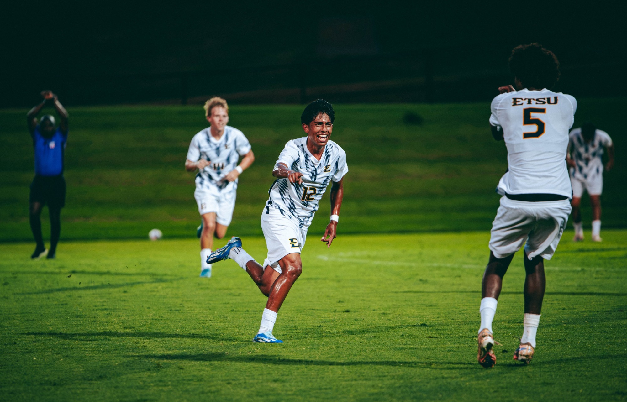 Joe Gonzalez points toward a teammate in the foreground as he celebrates a goal off a direct free kick during a soccer match against Belmont.