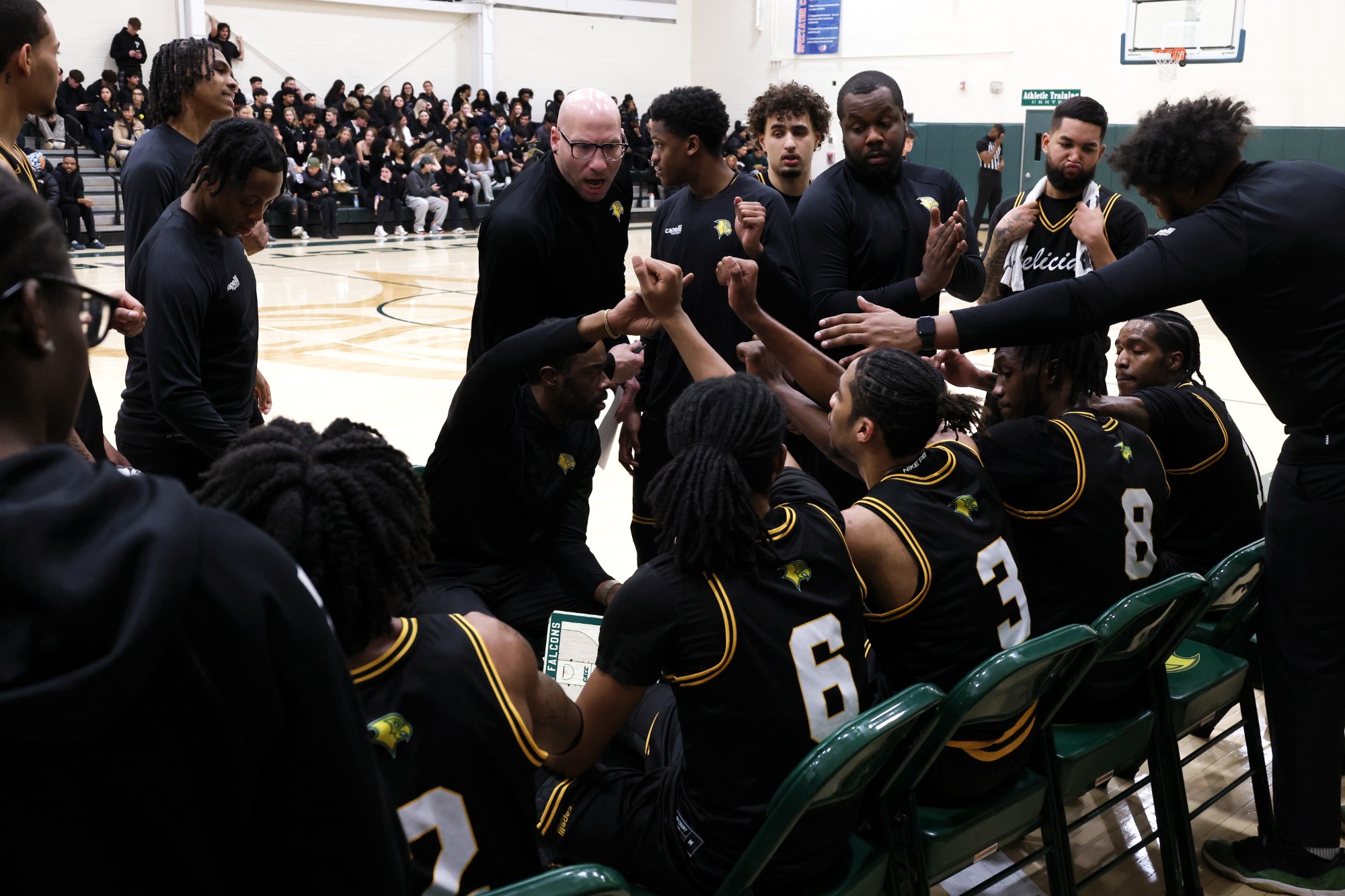 Team sits in a huddle during a timeout.