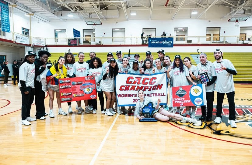 Women's Basketball Team Holding CACC Championship Banner