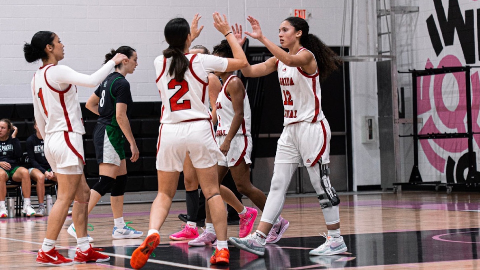 Ziul Gonzalez and Kaylee Llanos high-fiving against Ave Maria 2025-26