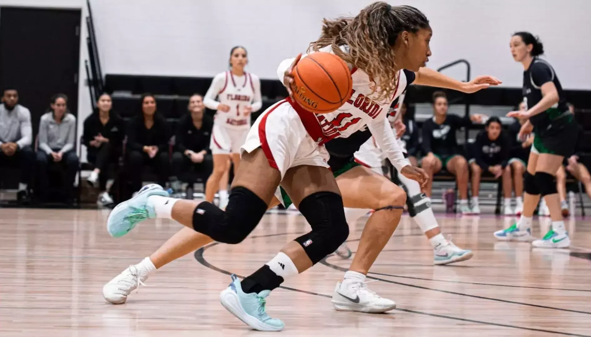 Hermione Hicks driving the basketball to the basket against Ave Maria University 2025-26