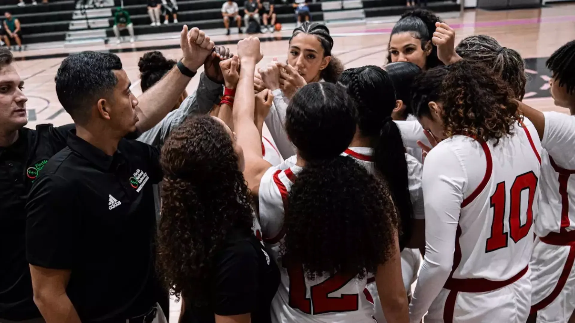 Women's basketball in a huddle before facing Ave Maria University 2025-26