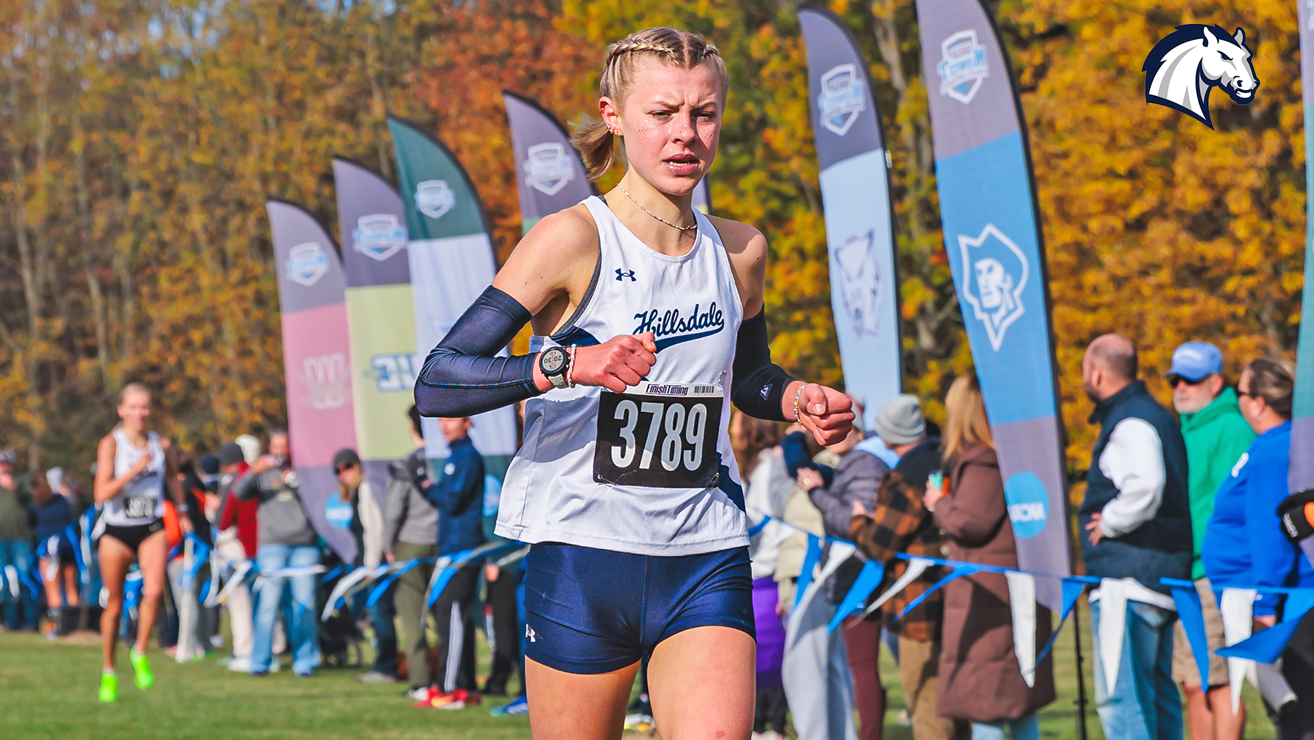 Hillsdale's Allison Kuzma crosses the finish line as the winner of the 2025 G-MAC Championships in Midland, Michigan.