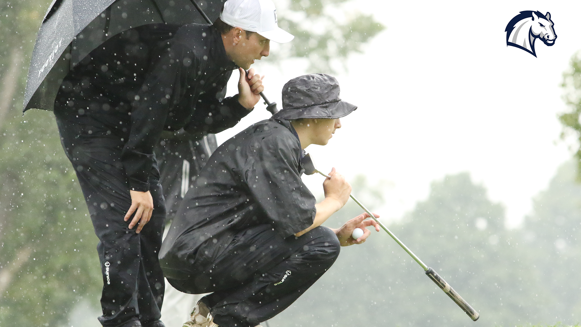 Chargers golfer Robert Thompson (right) discusses a putt with head coach Luke Kelly during the UIndy Invite on Sept. 21, 2025.