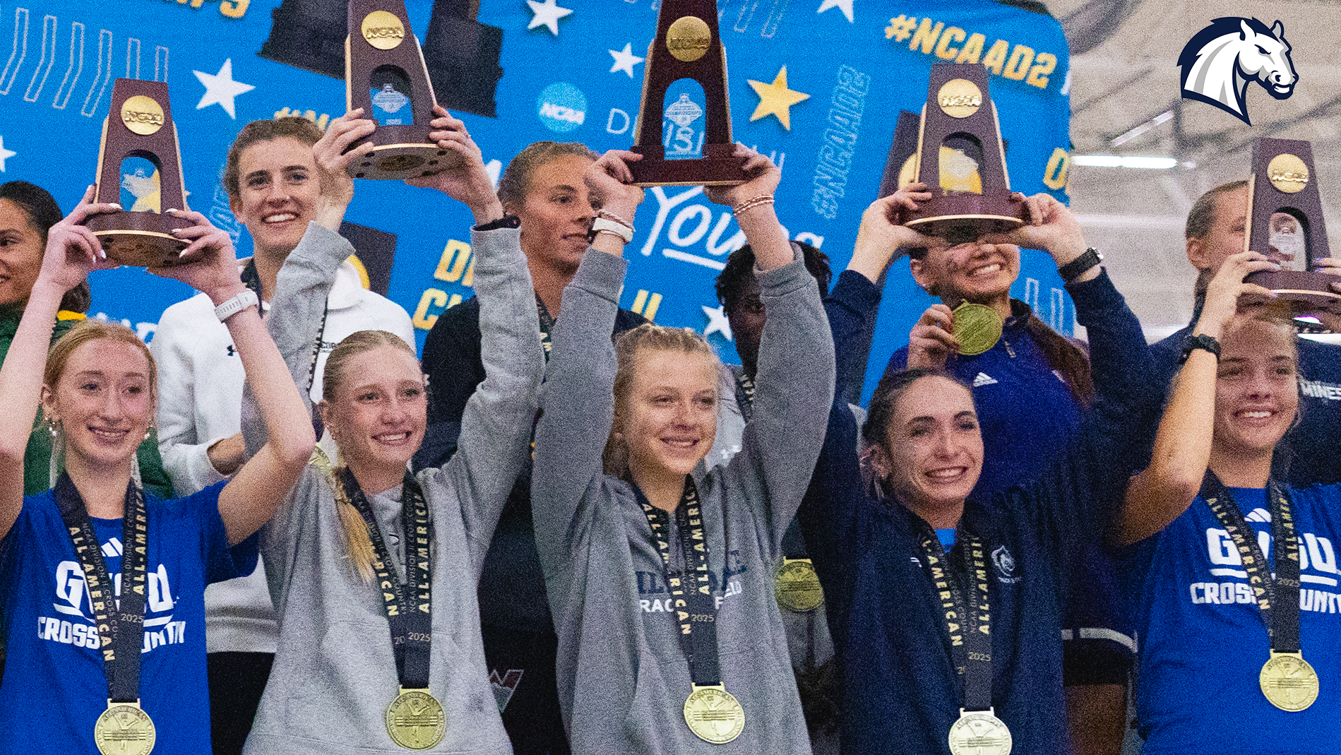 Allison Kuzma (center) holds up her trophy after an All-American finish at the 2025 NCAA DII Cross Country championships in Kenosha, Wisconsin on Nov. 22, 2025.