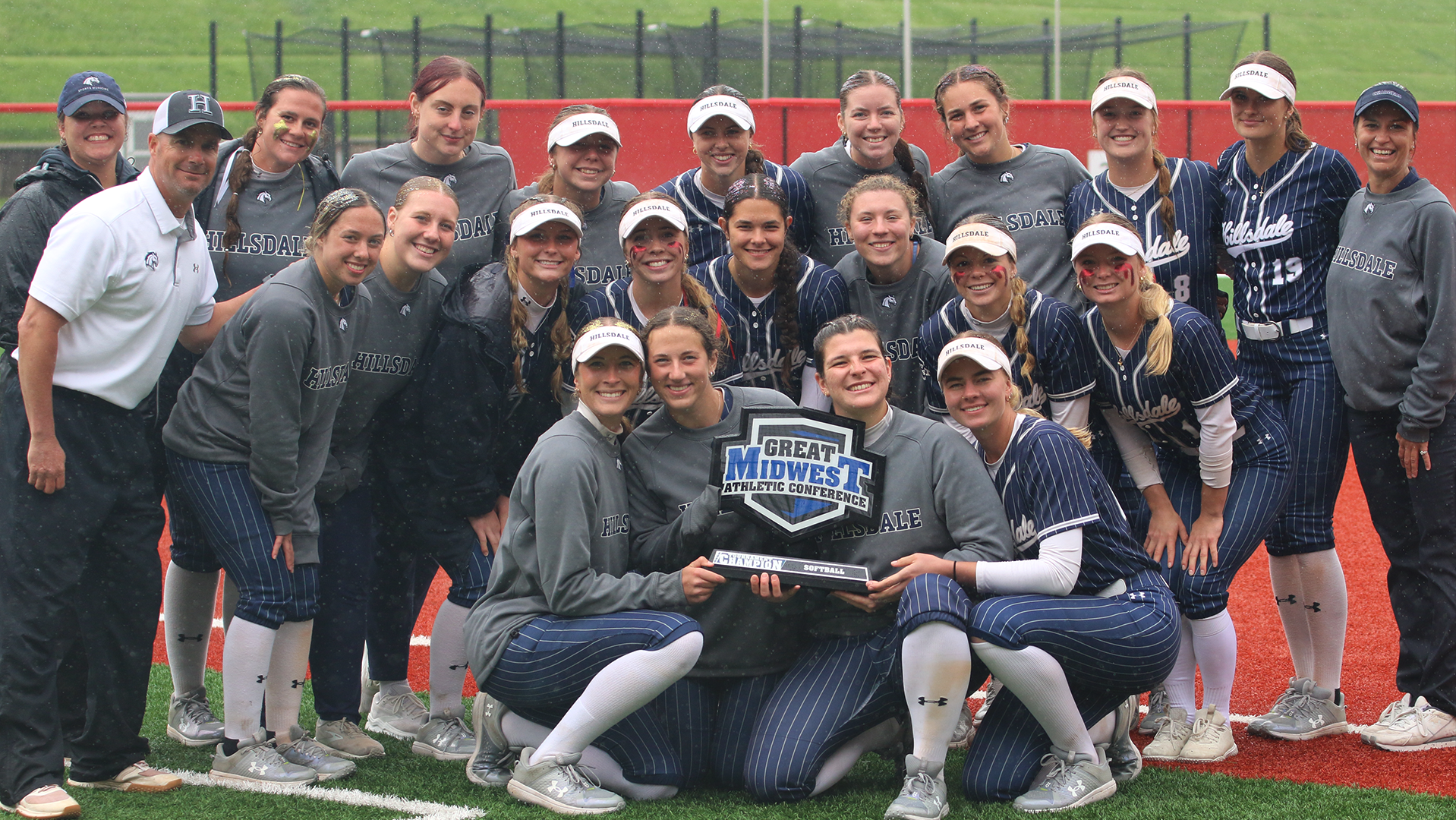 Hillsdale's softball team poses with the G-MAC Tournament trophy after winning the championship in Akron in 2025.