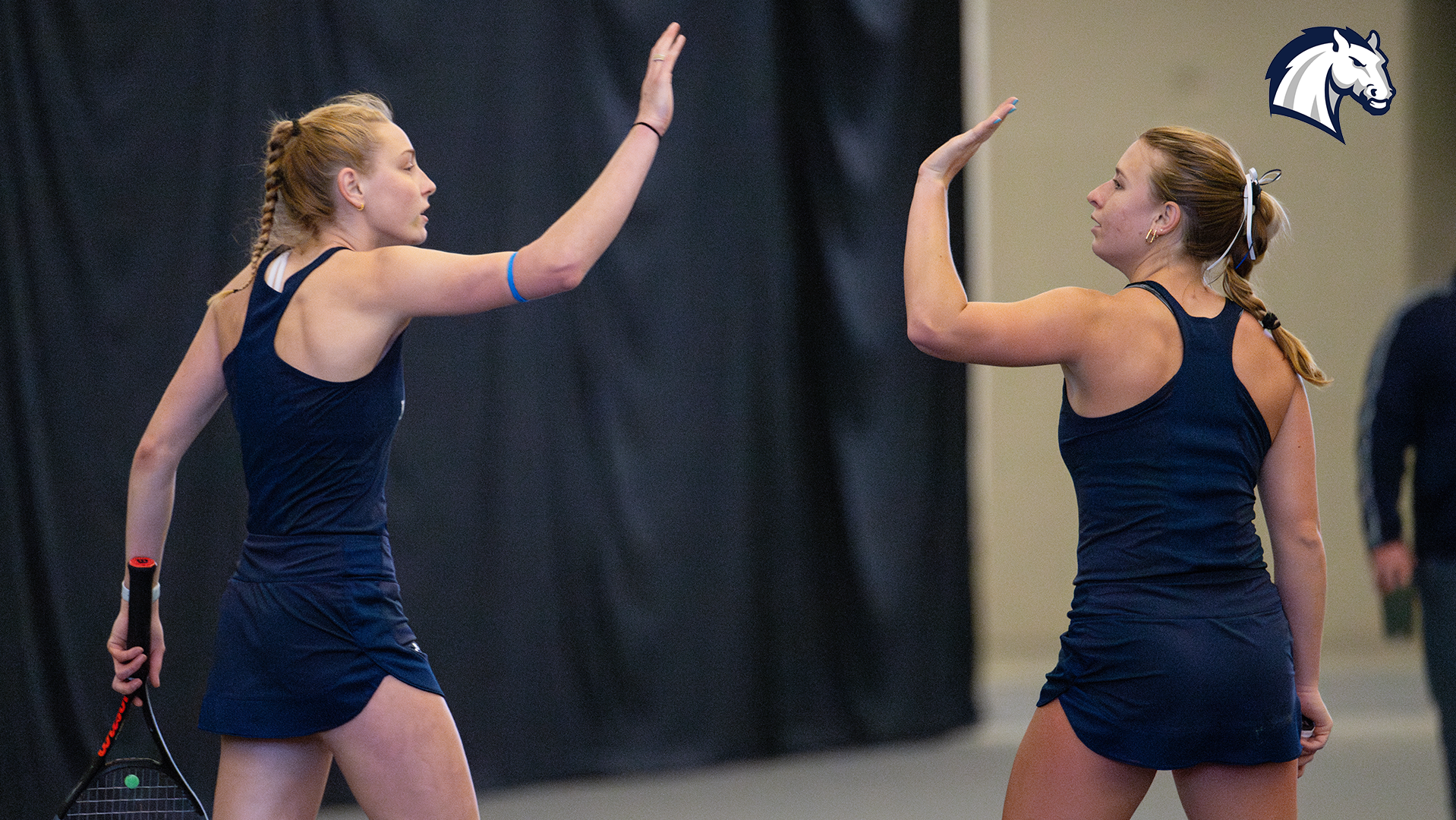 Hillsdale's Megan Hackman (left) and Courtney Rittel congratulate each other after a point in a match against Northwood on April 12, 2025.