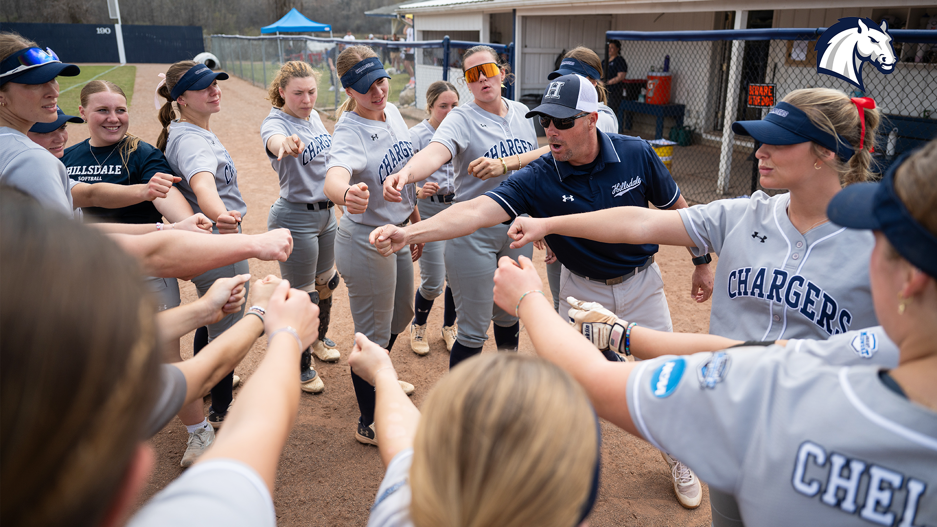 Hillsdale's players break a huddle in between innings during a 2025 game at home against Ohio Dominican.