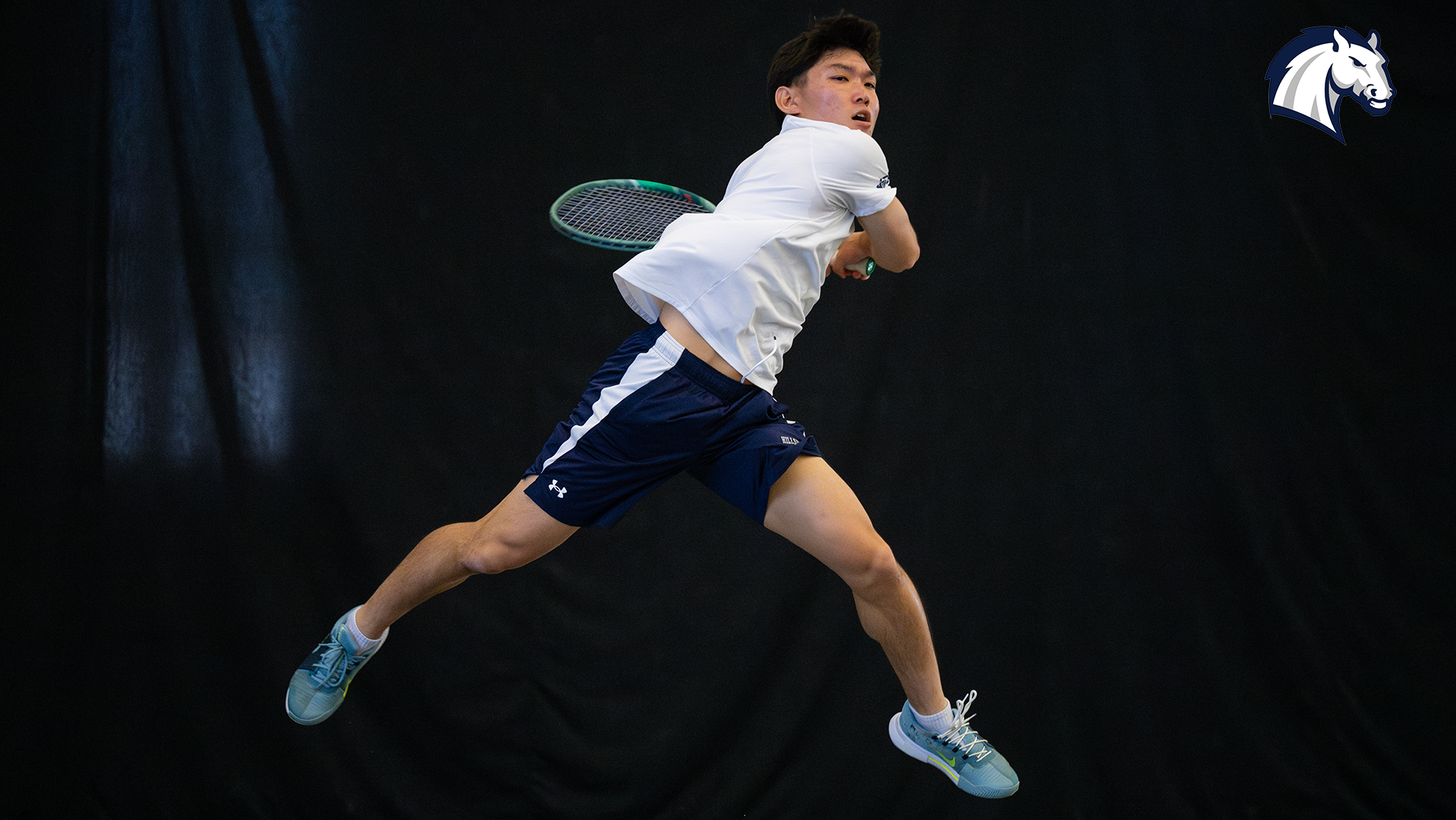 Hillsdale's Rintaro Goda leaps in the air to hit a return shot against Northwood in April 2025.