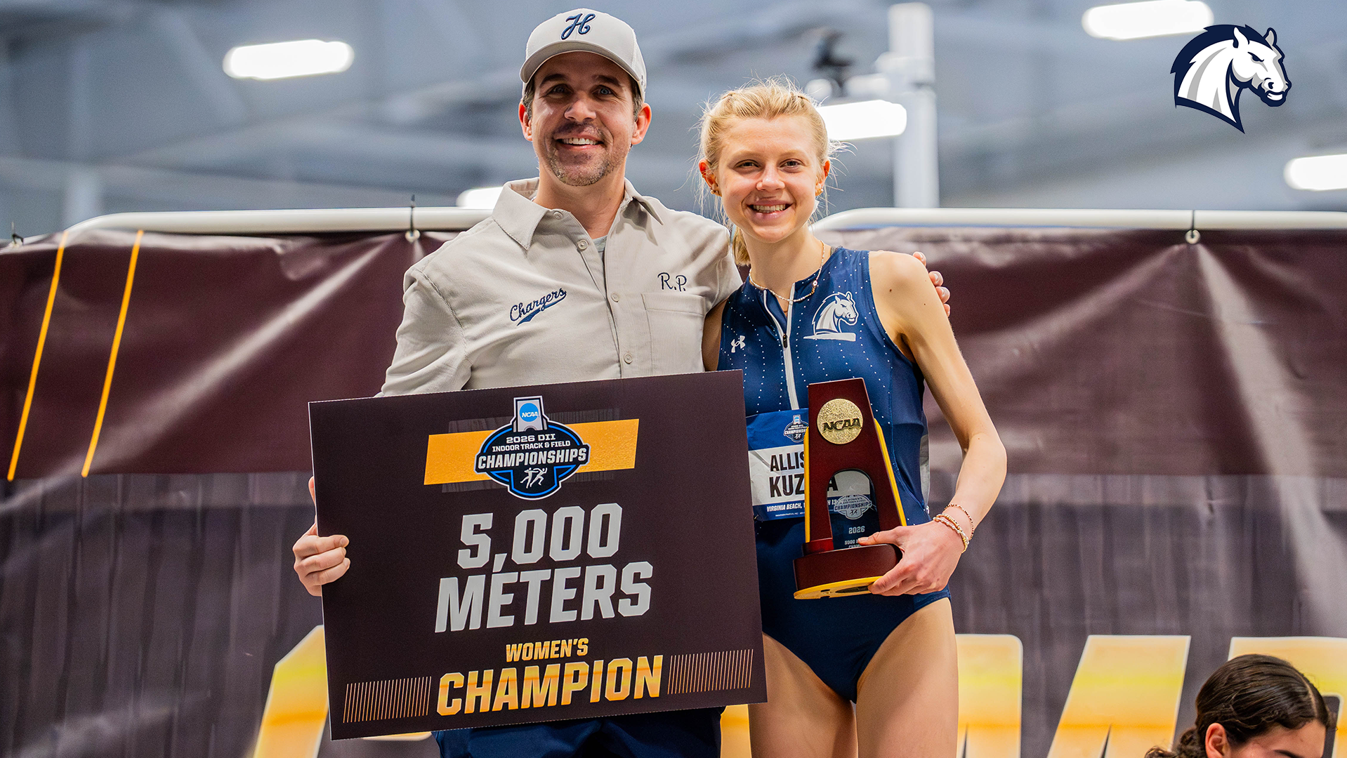 Hillsdale's Allison Kuzma (right) poses with Chargers coach R.P. White after winning the 2026 NCAA DII Indoor 5,000m title on March 13, 2026.